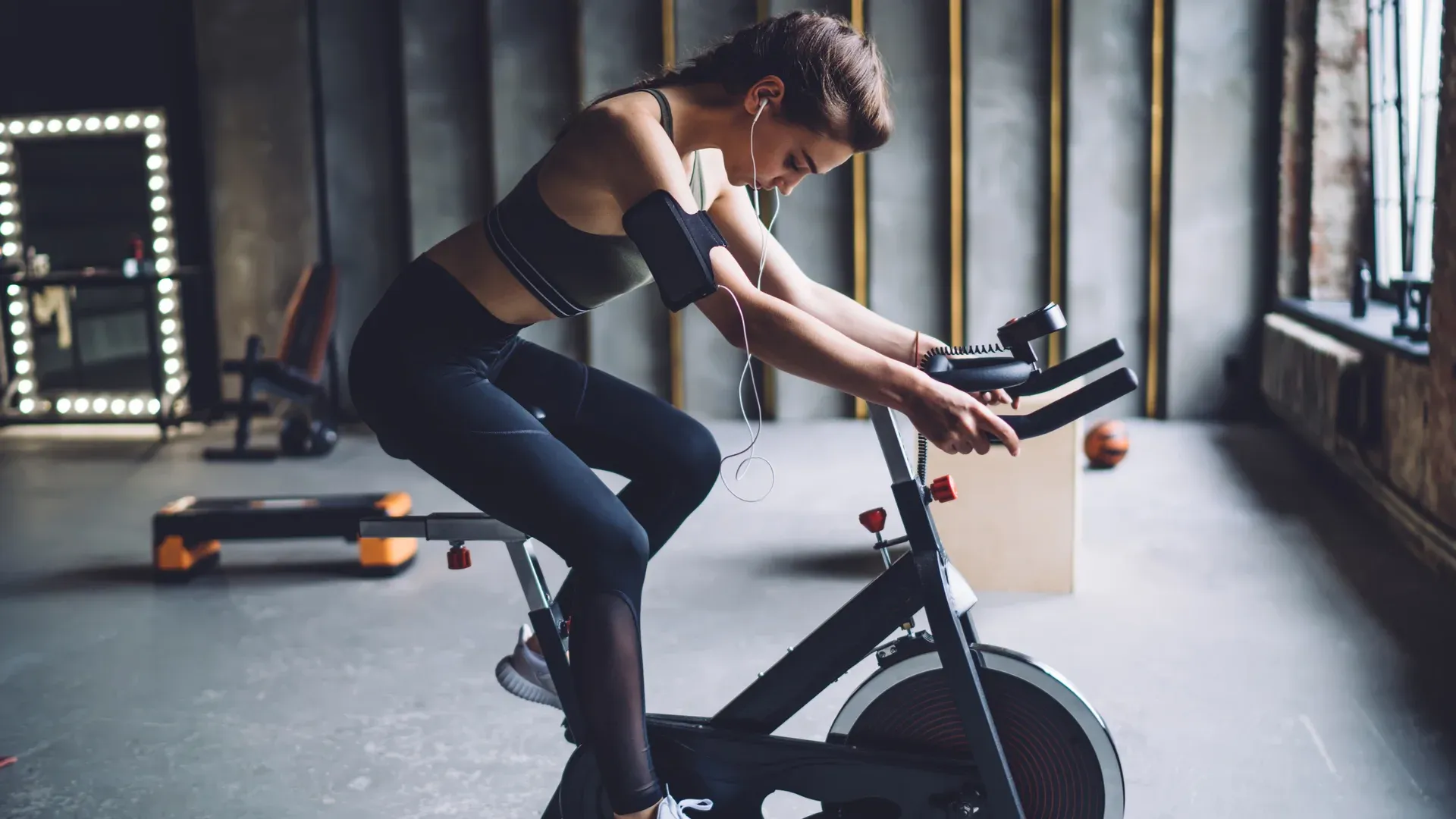 Mulher pratica exercício cardio na bicicleta de spinning