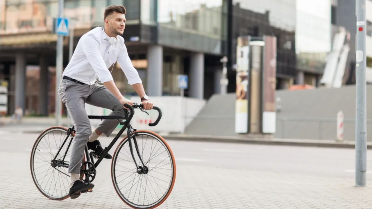 Homem caucasiano pedalando em cidade