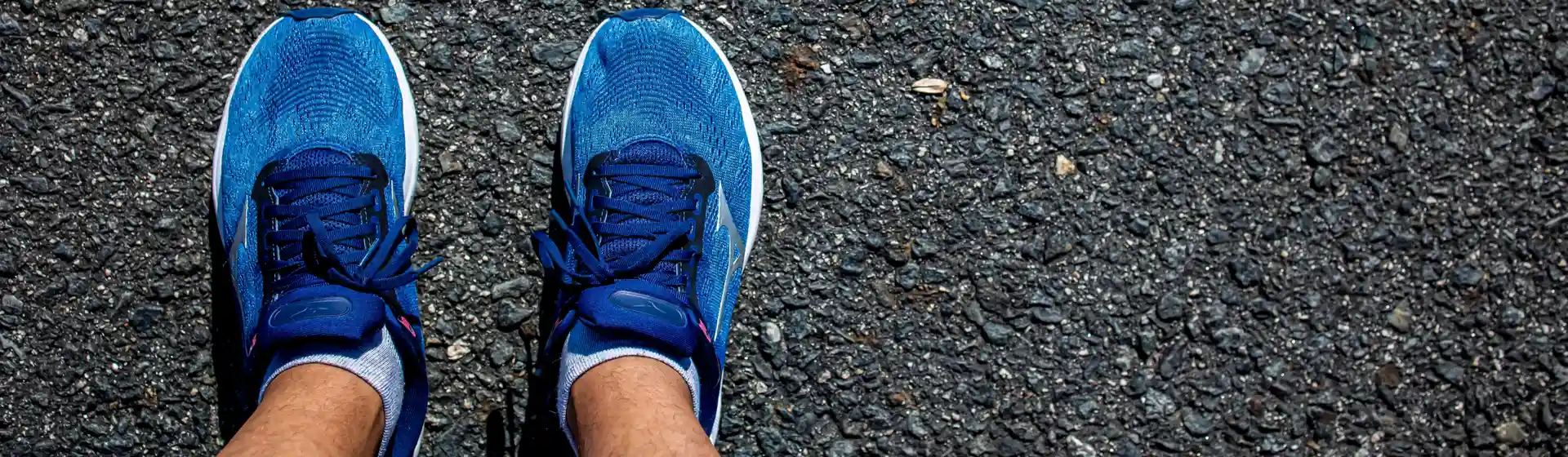 Close nos pés de um homem usando tênis mizuno azul