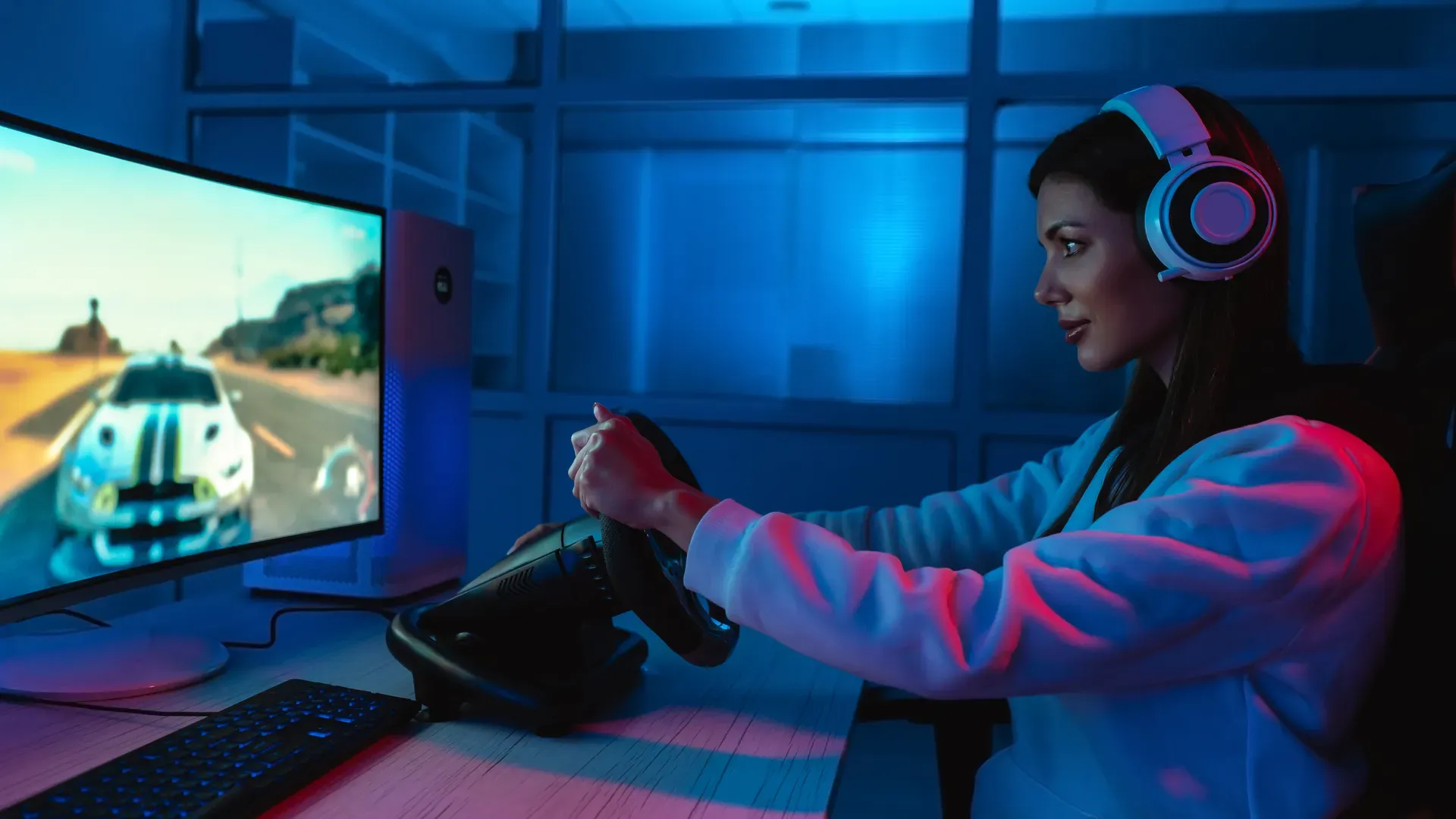 Mulher numa cadeira usando um volante para PC para jogar um jogo de corrida