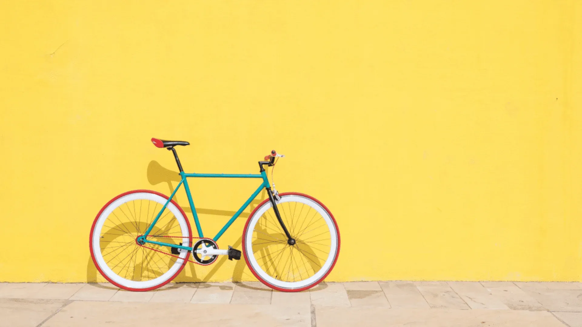 Bicicleta azul em frente de parede amarela