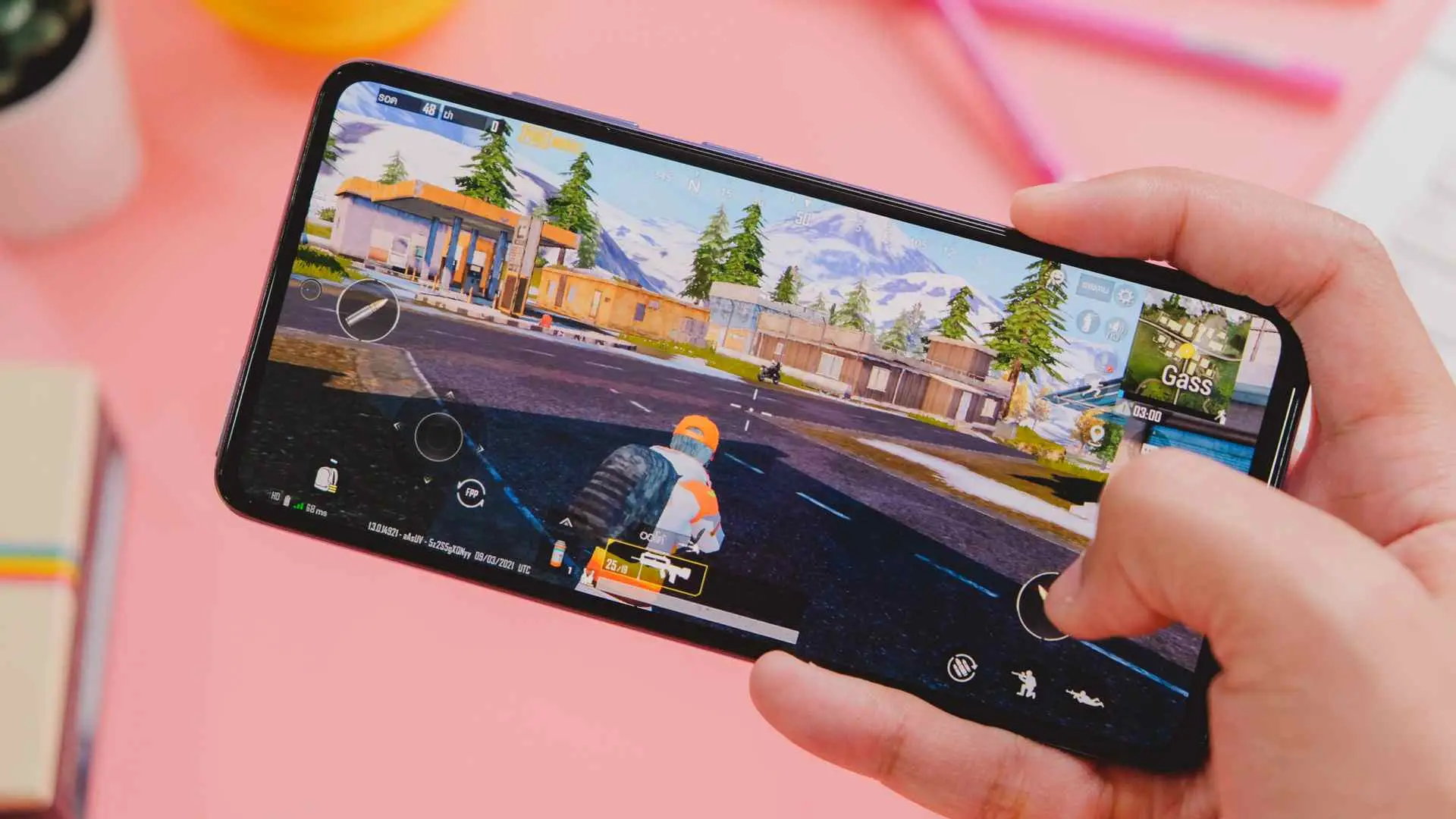 Mão segurando seu Galaxy A72 jogando um game com fundo rosa
