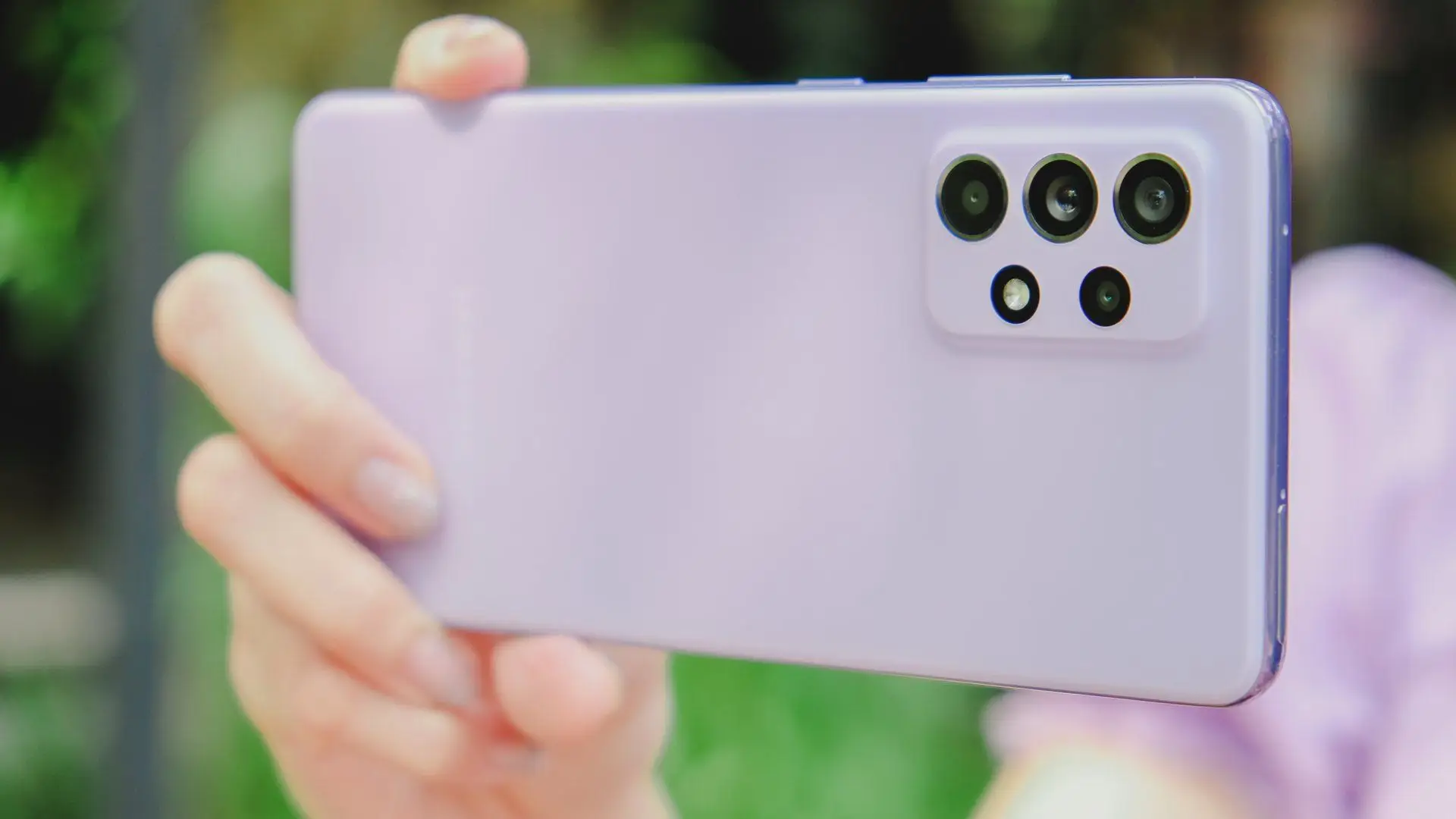 Mãos femininas segurando Galaxy A52 roxo para tirar fotografia