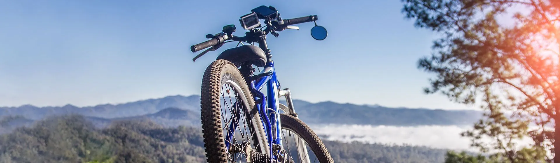 Bicicleta azul estacionada com paisagem de montanhas atrás