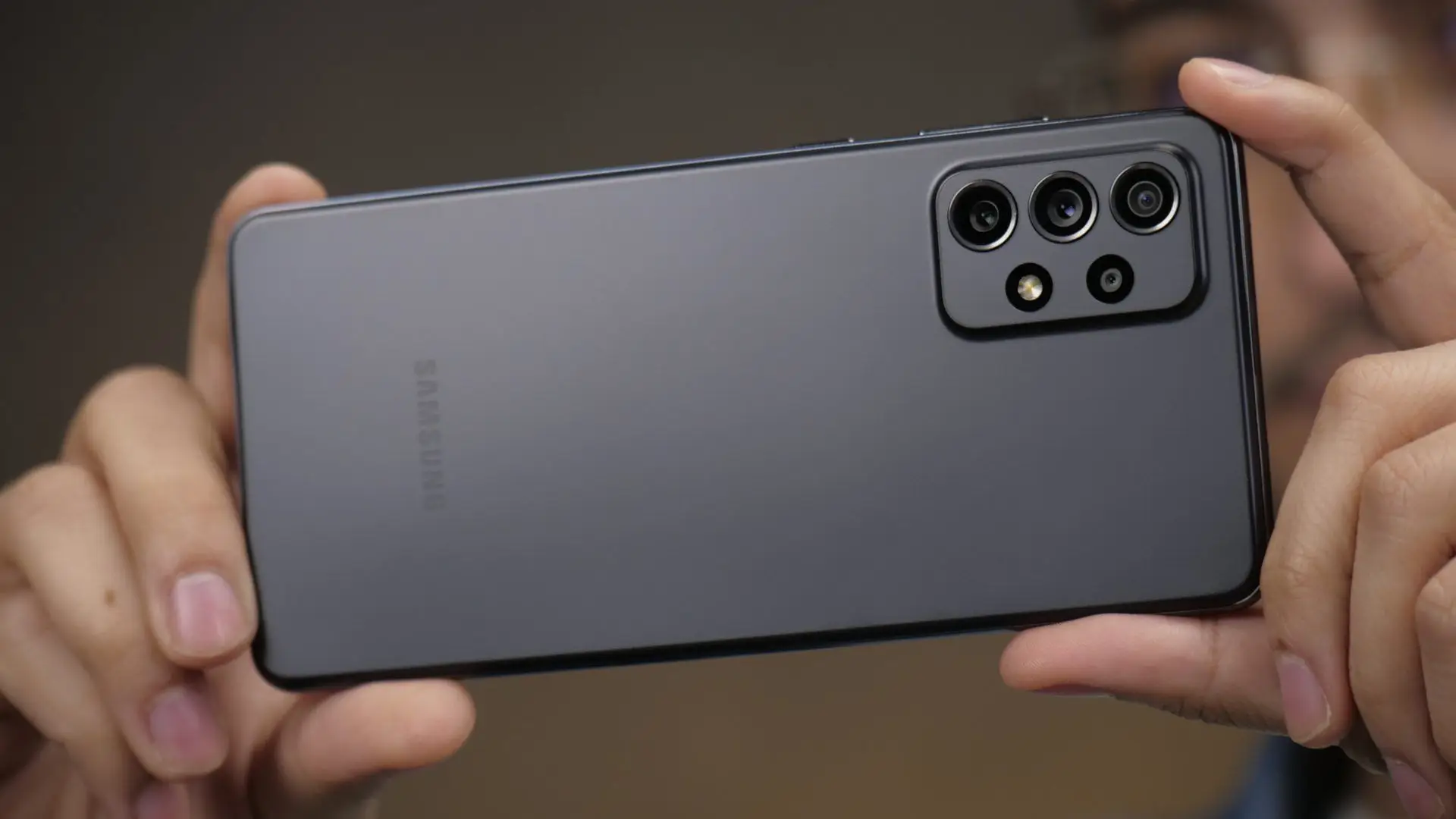 Mãos femininas segurando Galaxy A72 preto para tirar fotografia