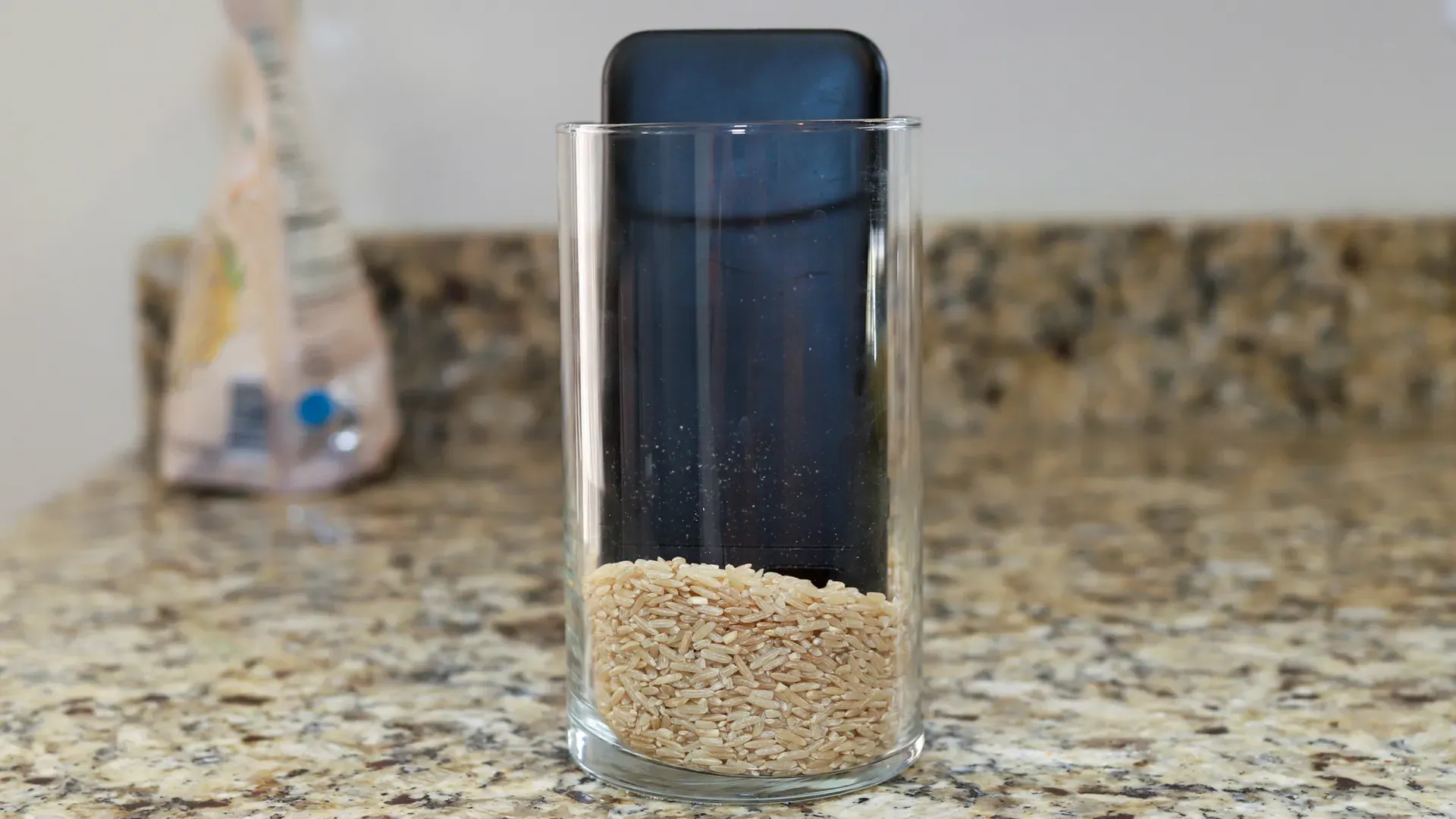Celular desligado dentro de um copo com arroz