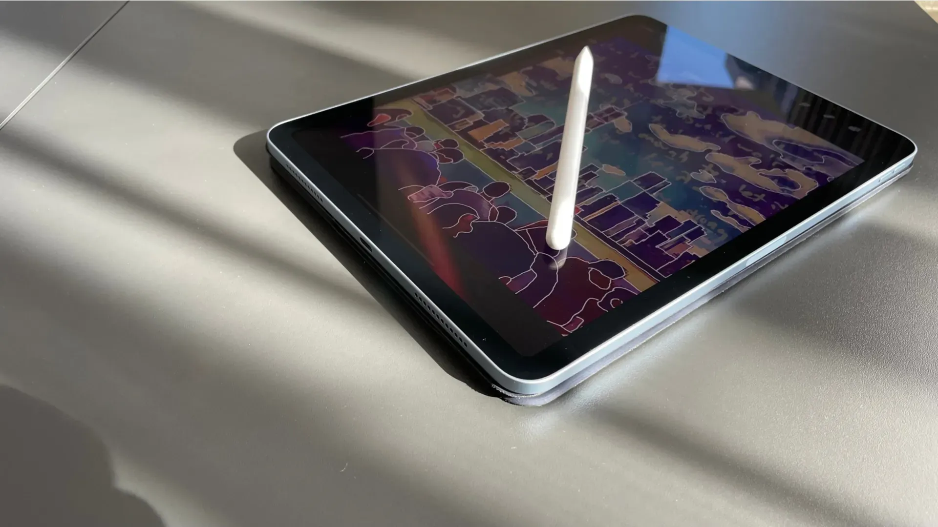Detalhe do iPad Air 4ª geração sobre uma mesa, com um desenho e uma Apple Pencil na tela