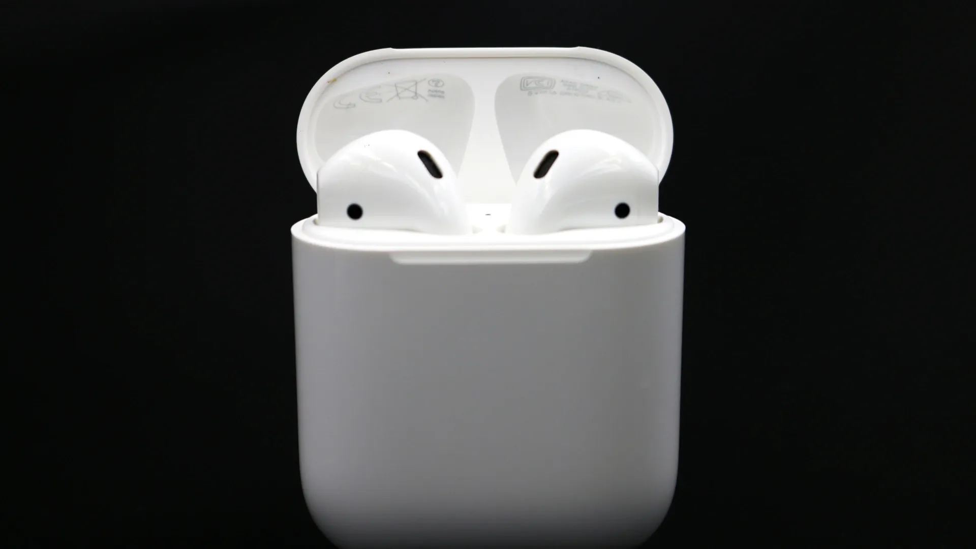 Fone Apple AirPods 2 em seu estojo carregador em fundo preto