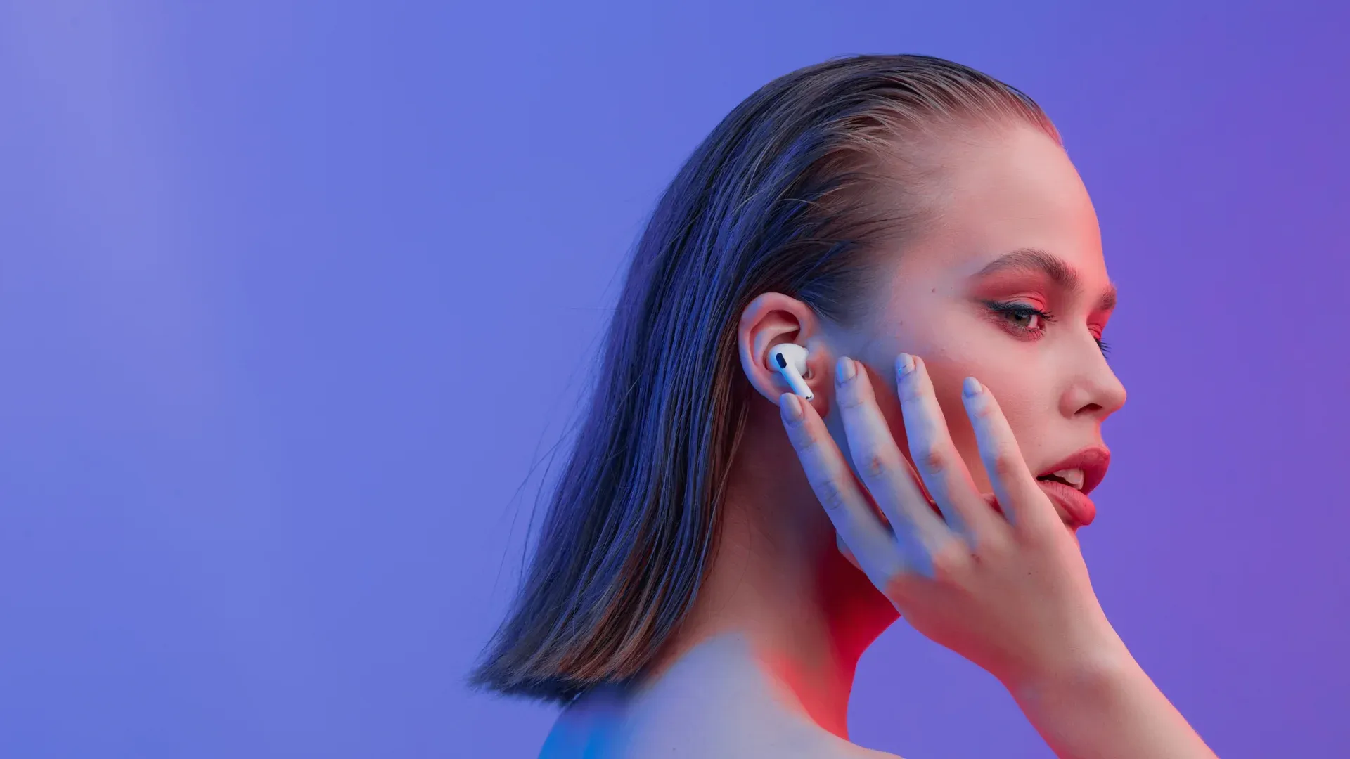 Mulher curte sua música em seu fone Bluetooth Apple AirPods Pro em fundo roxo