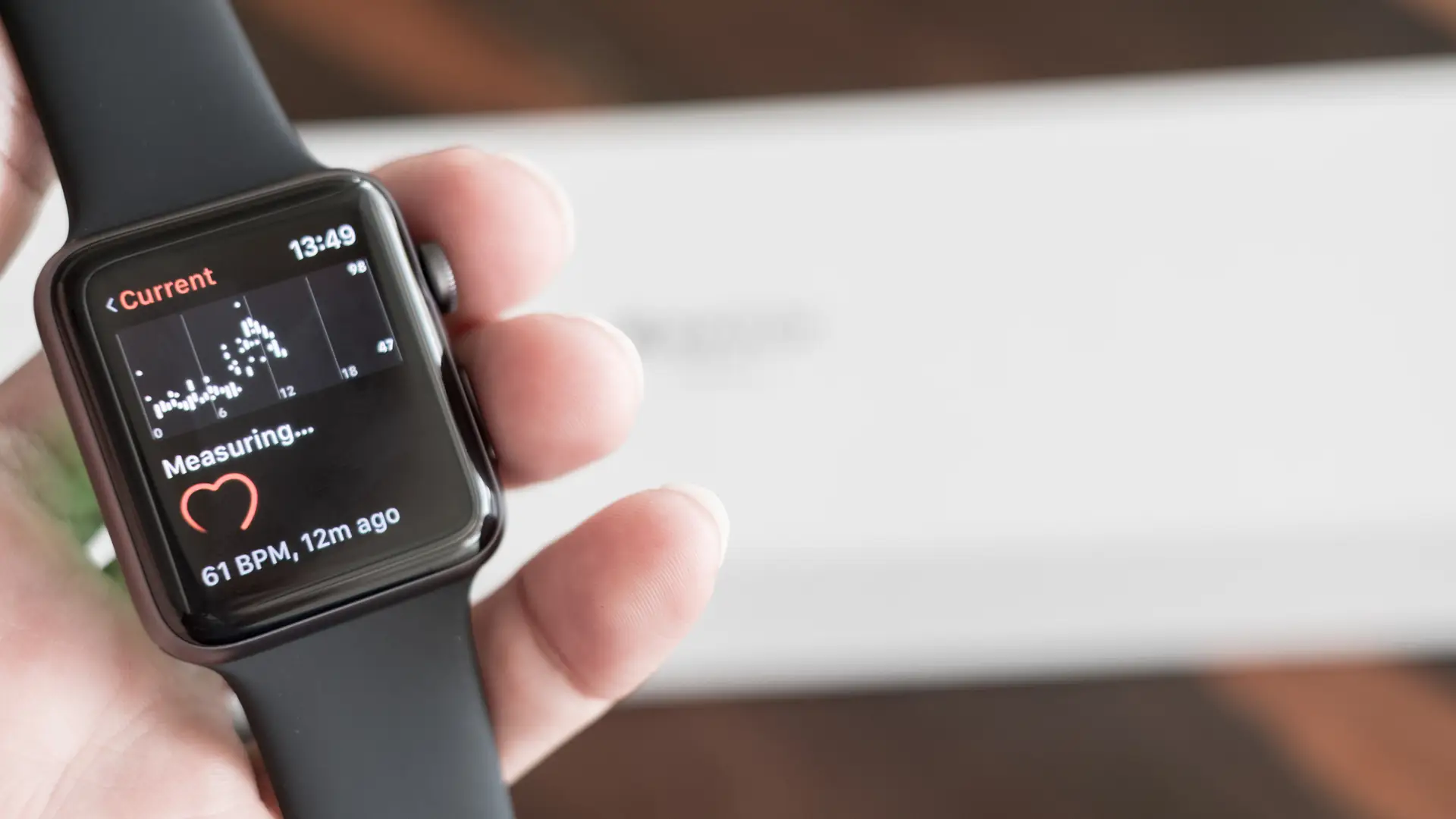 Apple Watch 3 com pulseira preta de silicone medindo batimentos cardíacos