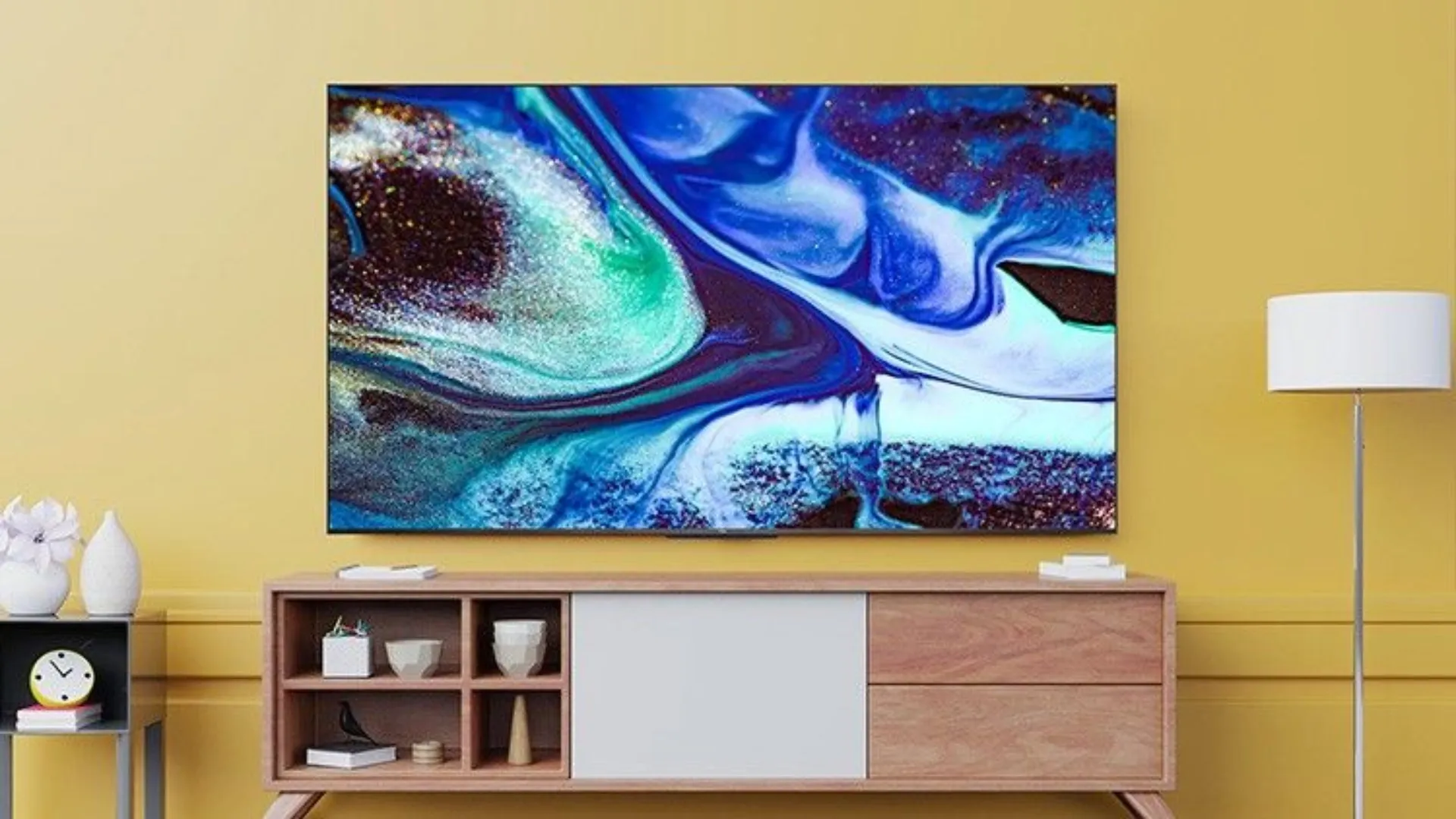 TV ligada pendurada na parede em uma sala de estar com uma pintura na tela