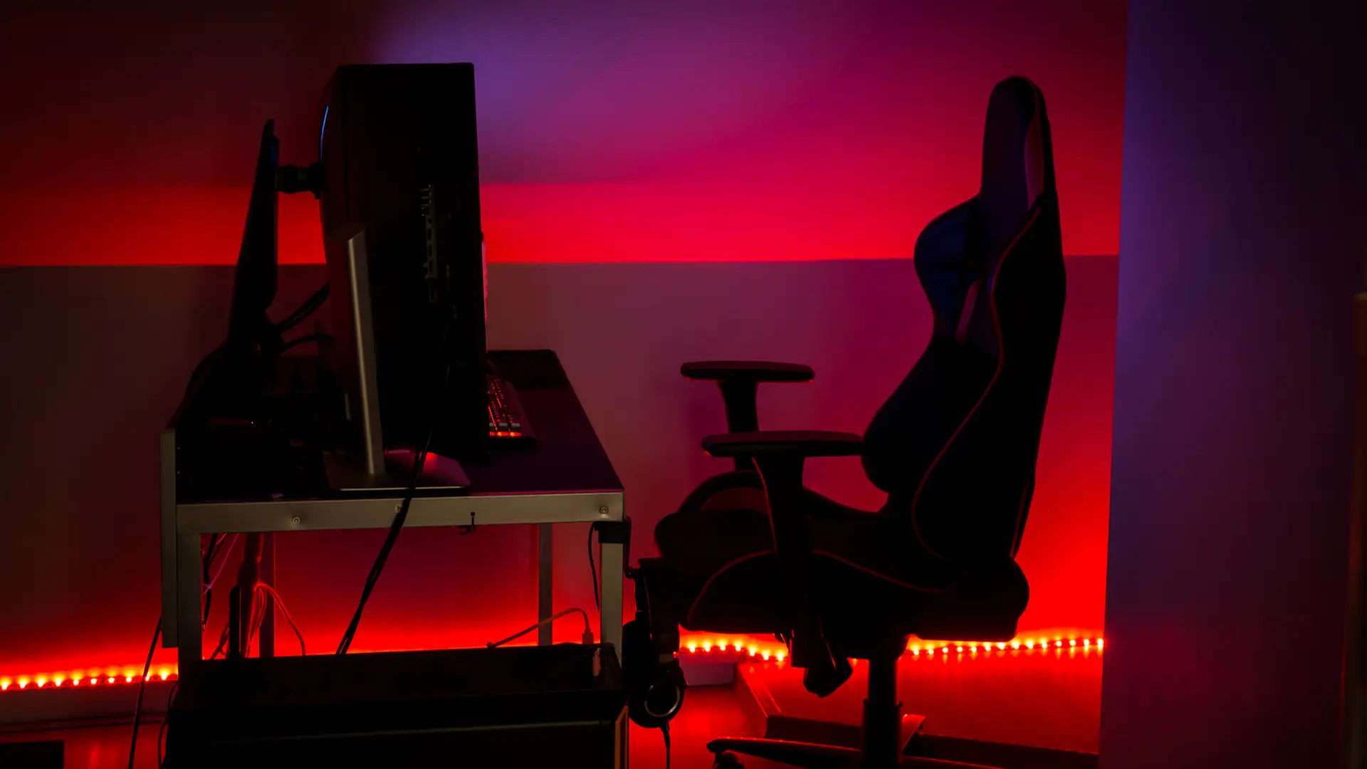 Um quarto gamer masculino decorado com luz de LED vermelha