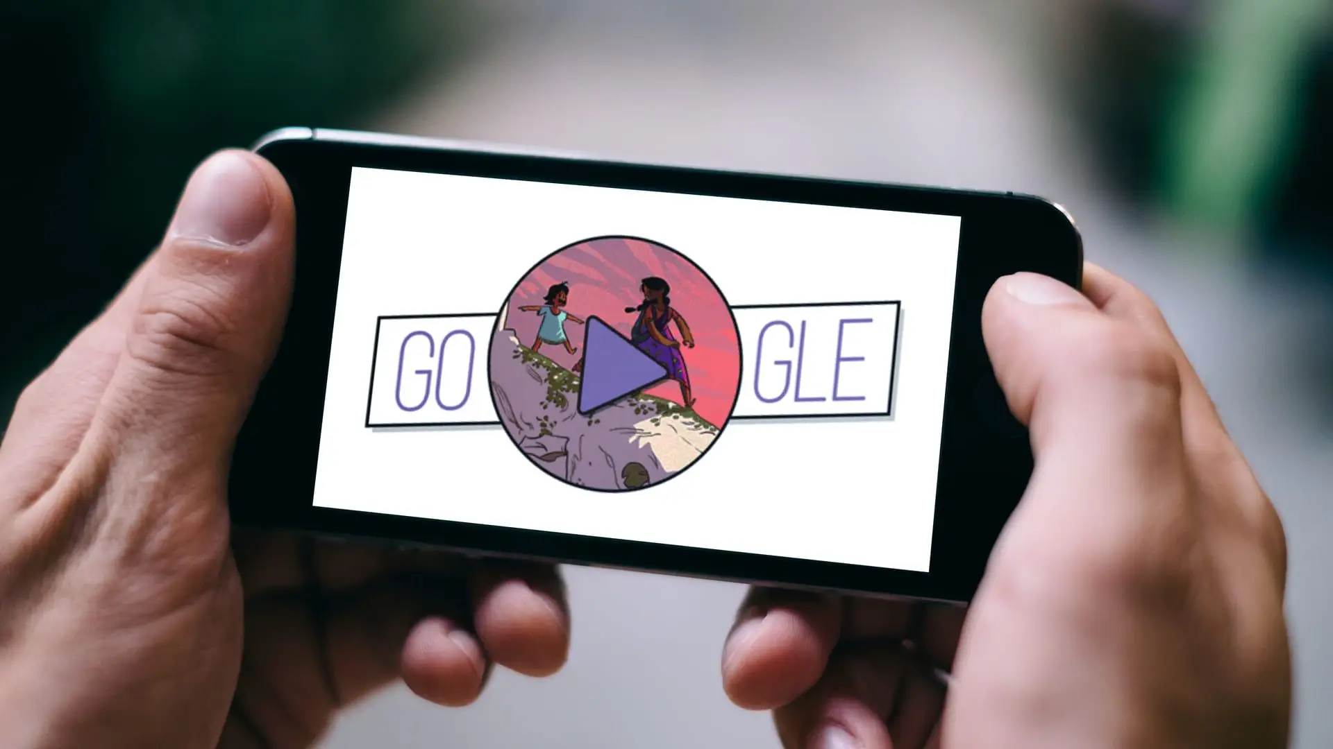 Duas mãos seguram um celular que mostra, na tela, um jogo do Google