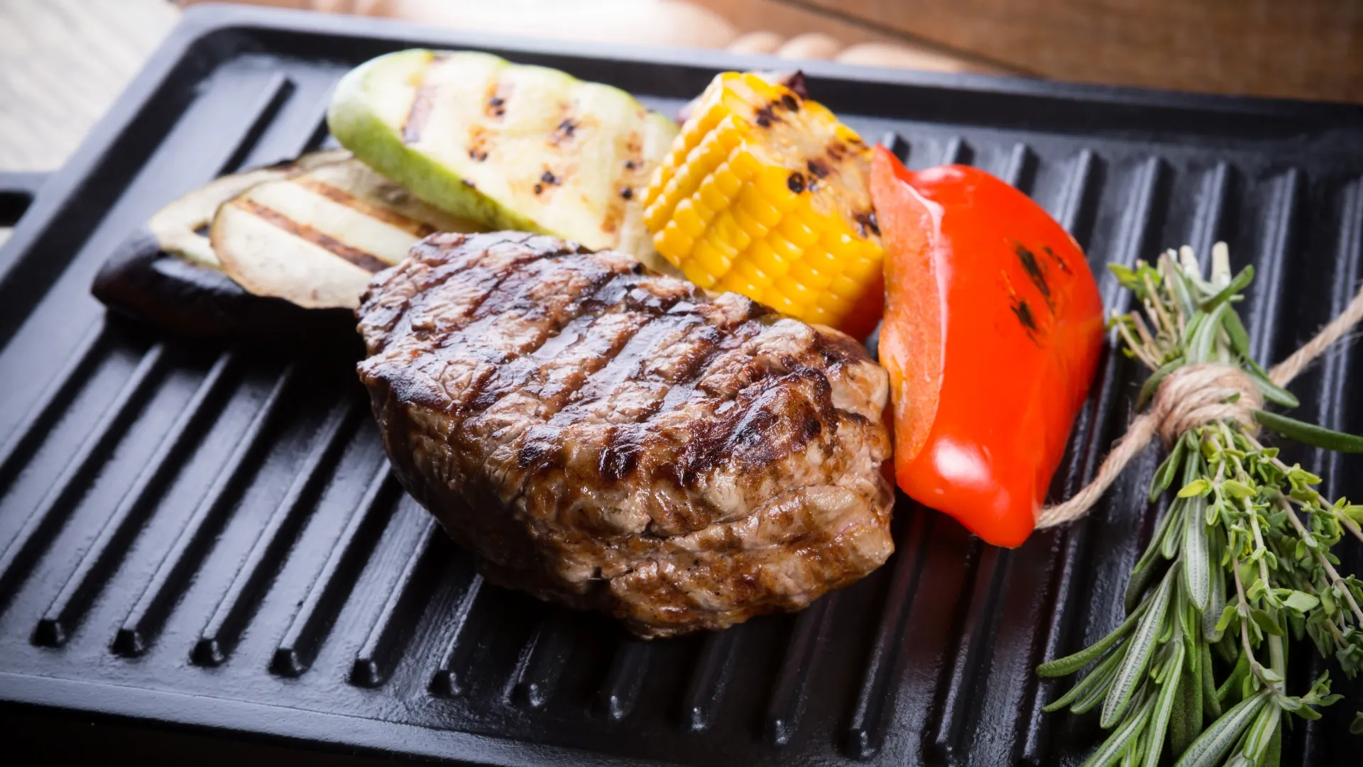 Carnes e vegetais sendo grelhadas em um grill
