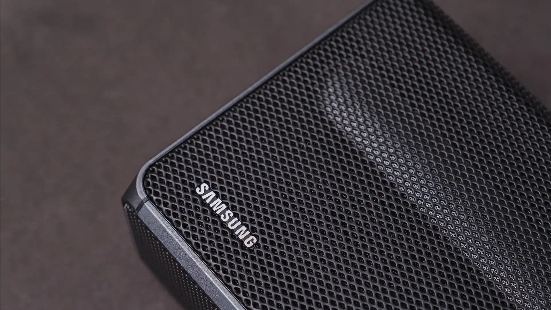 Close no canto da soundbar Samsung HW-Q600A, com o escrito "Samsung"