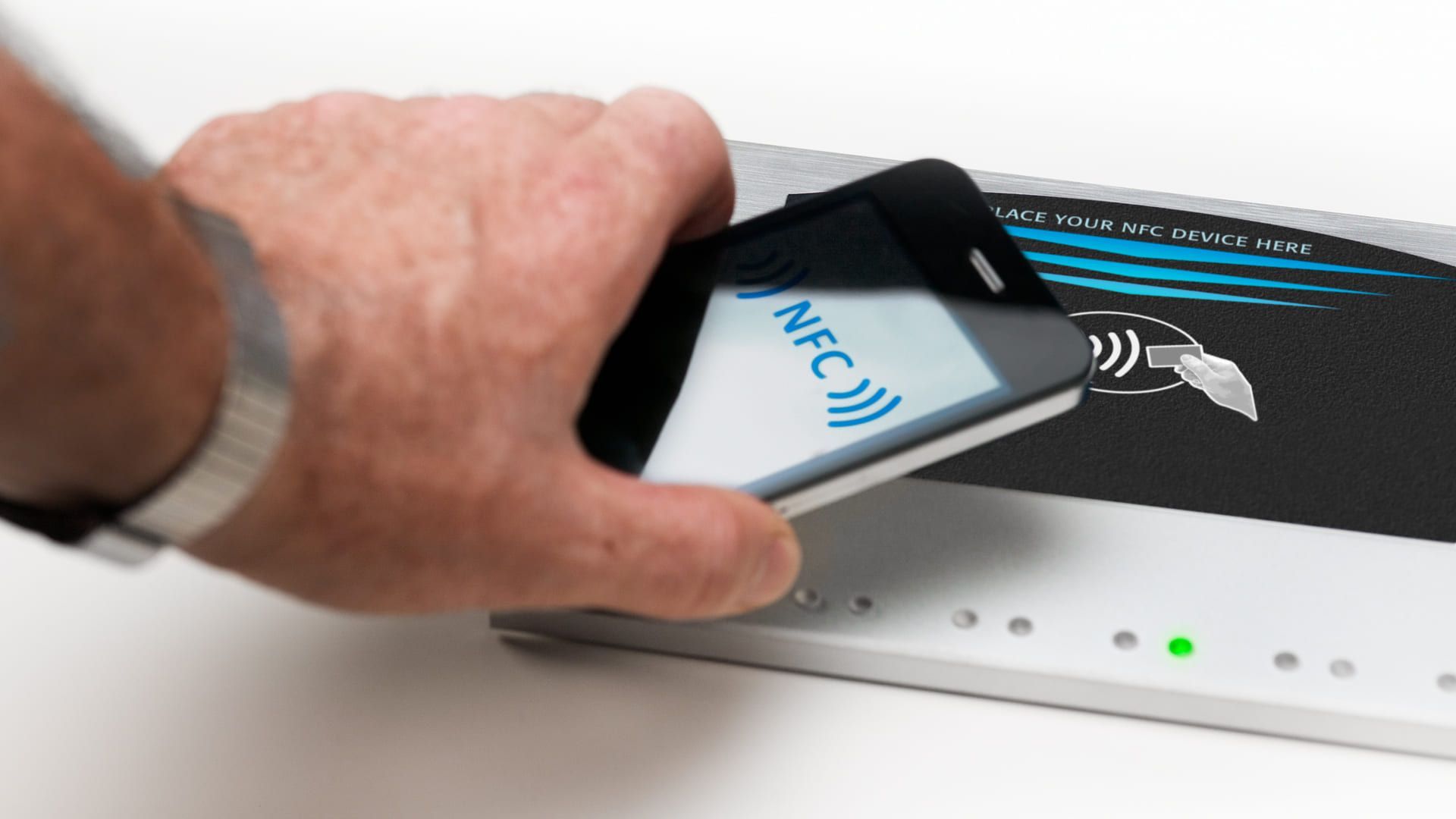 Homem aproxima NFC celular de dispositivo com a mesma tecnologia