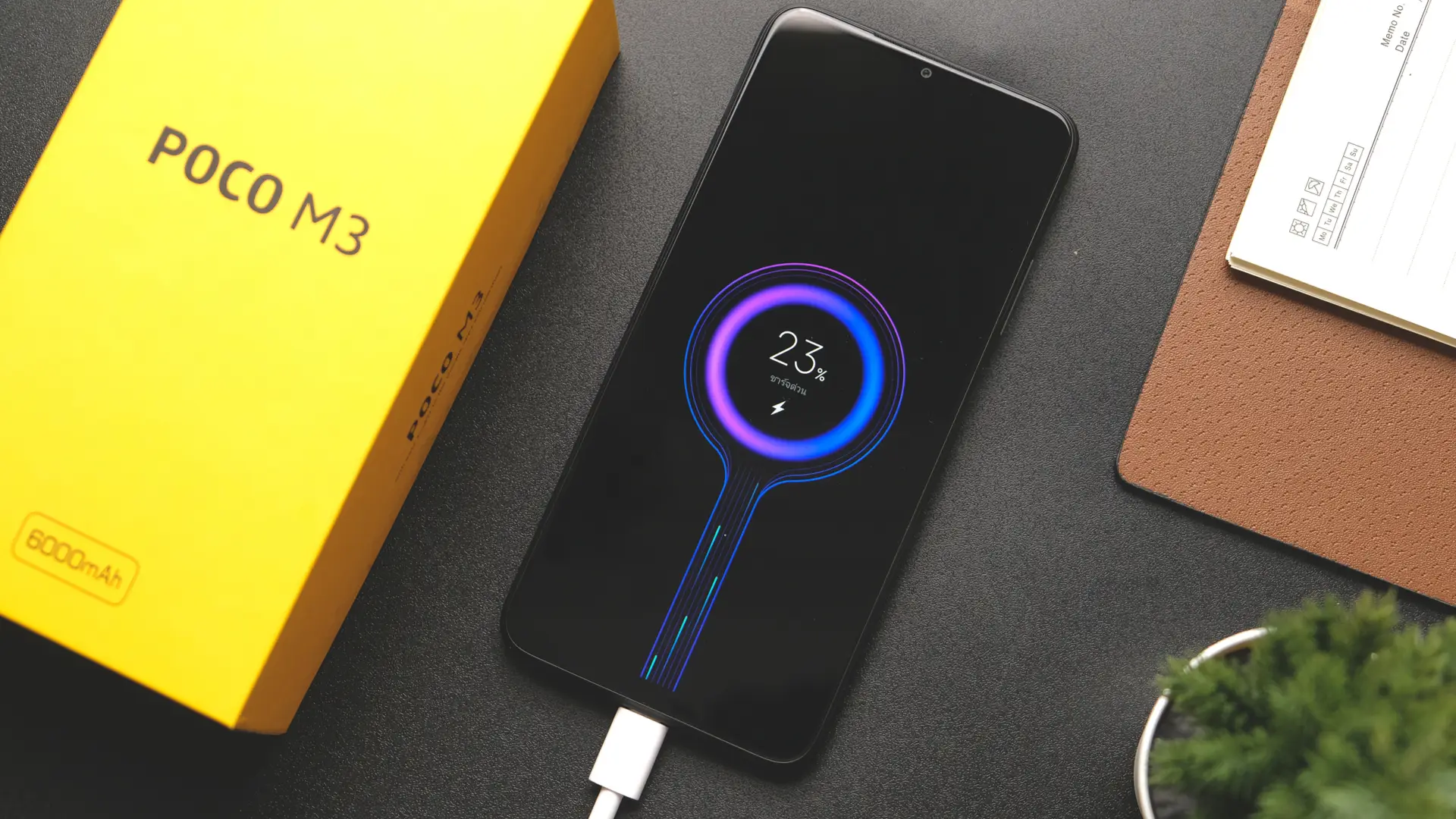 Celular Poco M3 no carregador em cima da mesa
