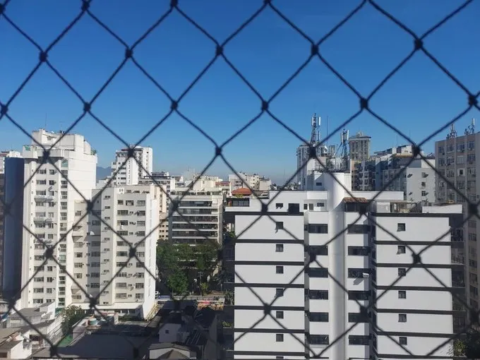 Foto de prédios à luz do dia com grade em primeiro plano