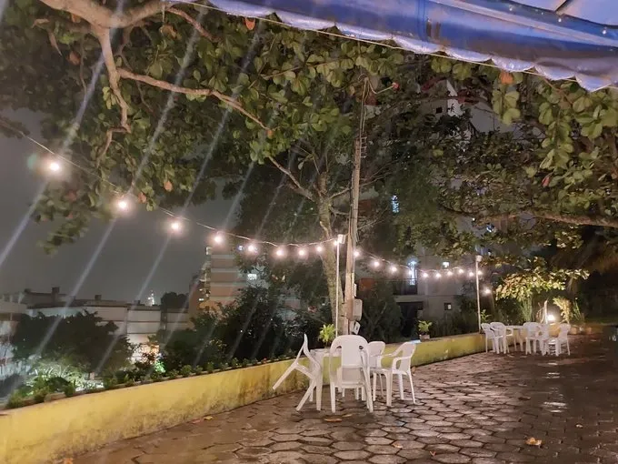 Foto noturna do M52 mostra plantas, cadeiras de plástica e chão de cimento