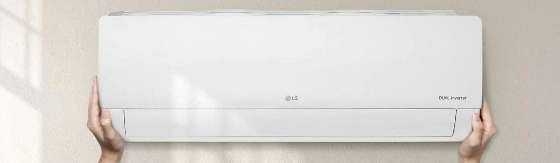 mãos brancas segurando Ar-condicionado LG Dual Inverter Compact
