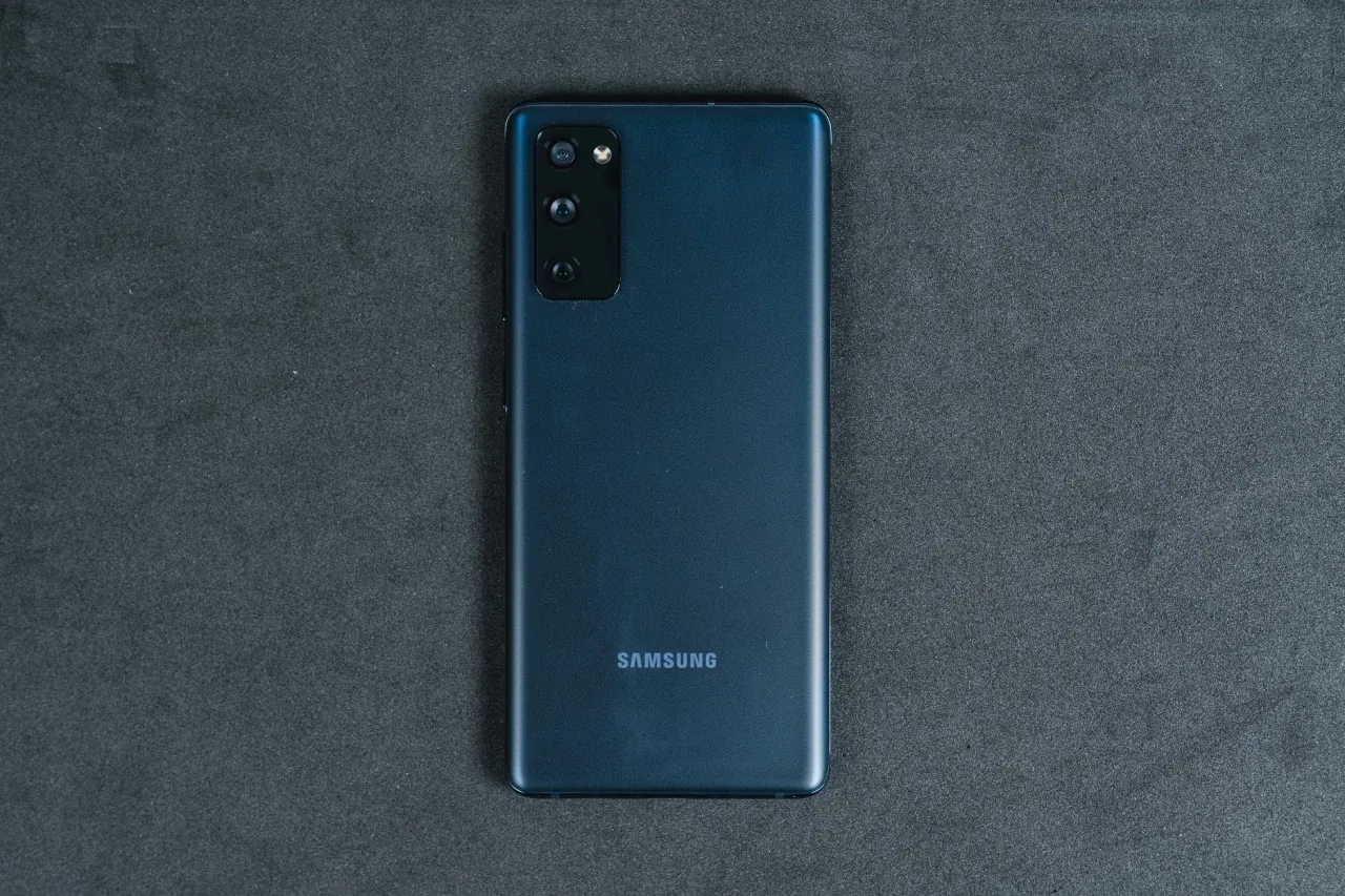 Foto da traseira do S20 FE com acabamento azul escuro, um conjunto de câmeras triplo na parte superior esquerda e o logo da Samsung centralizado na parte inferior