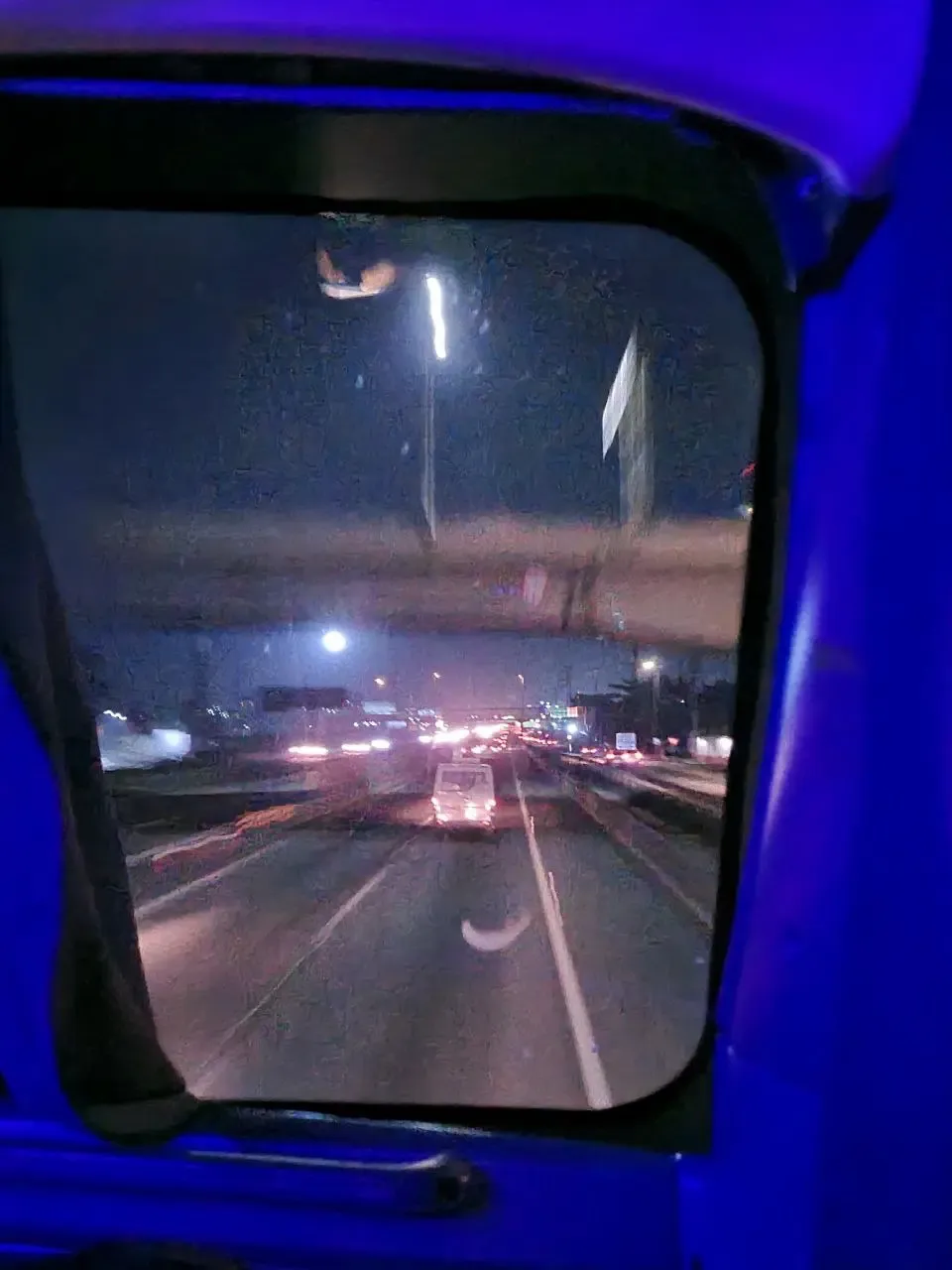 Foto da estrada tirada de dentro de um ônibus em movimento