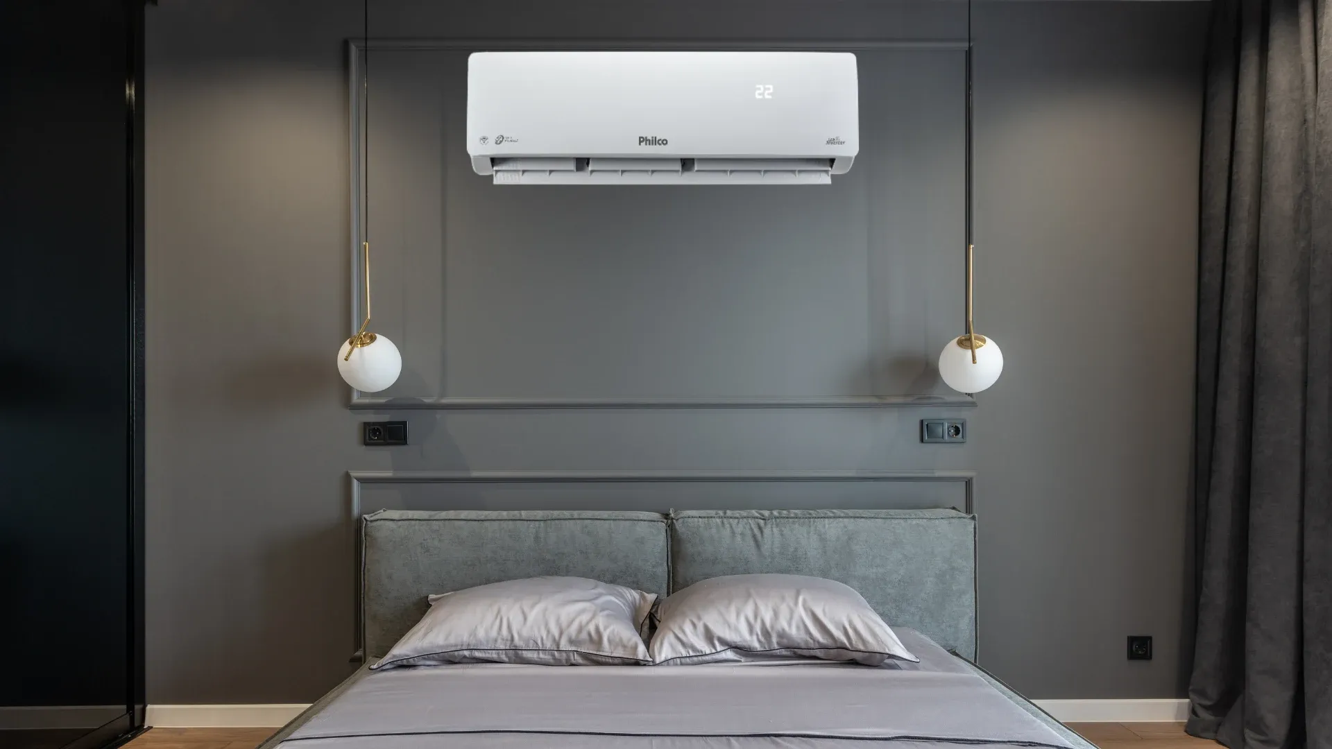 Ar-condicionado Philco Eco Inverter em parede preta sobre cama