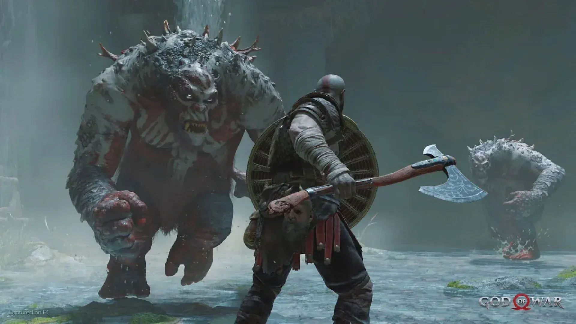 Imagem do jogo God of War com o protagonista Kratos no centro de costas segurando um machado na mão direita e um escudo na esquerda enquanto se prepara para enfrentar dois ogros, um de cada lado