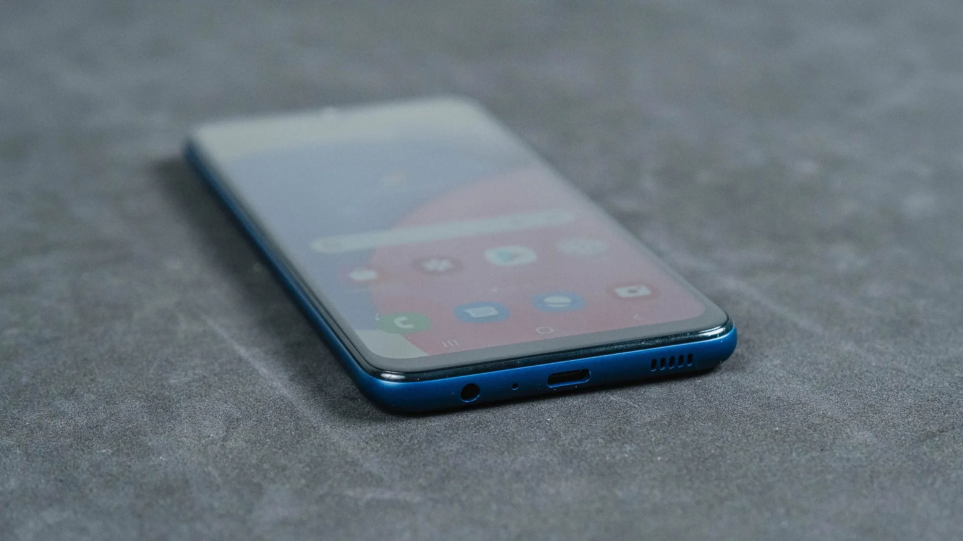 Smartphone Samsung Galaxy A03s deitado na diagonal sobre superfície cinza