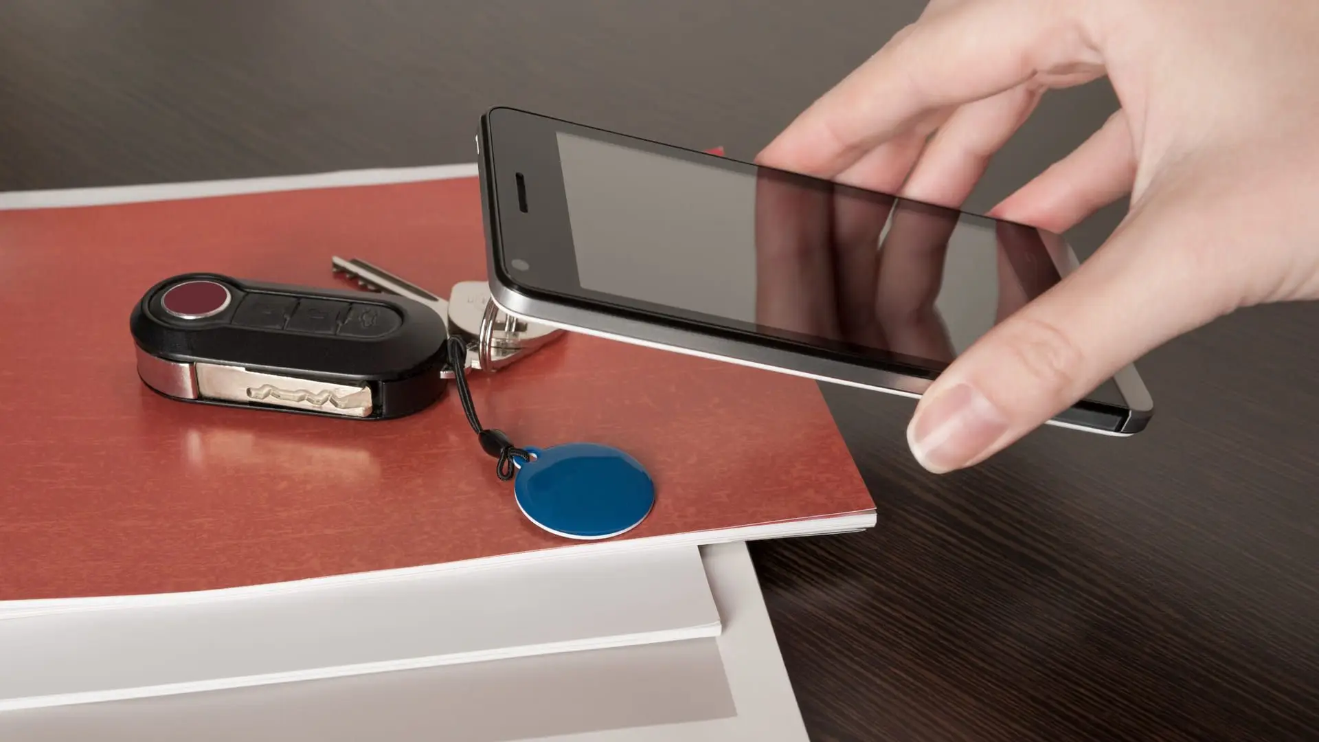 Mulher segura celular com tecnologia NFC próximo a chave de casa