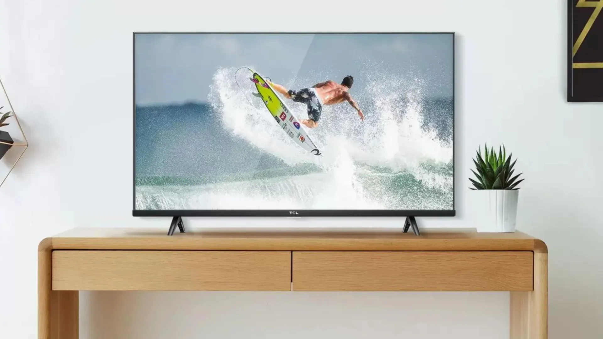 TV TCL S615 sobre aparador em uma sala, reproduzindo surfe