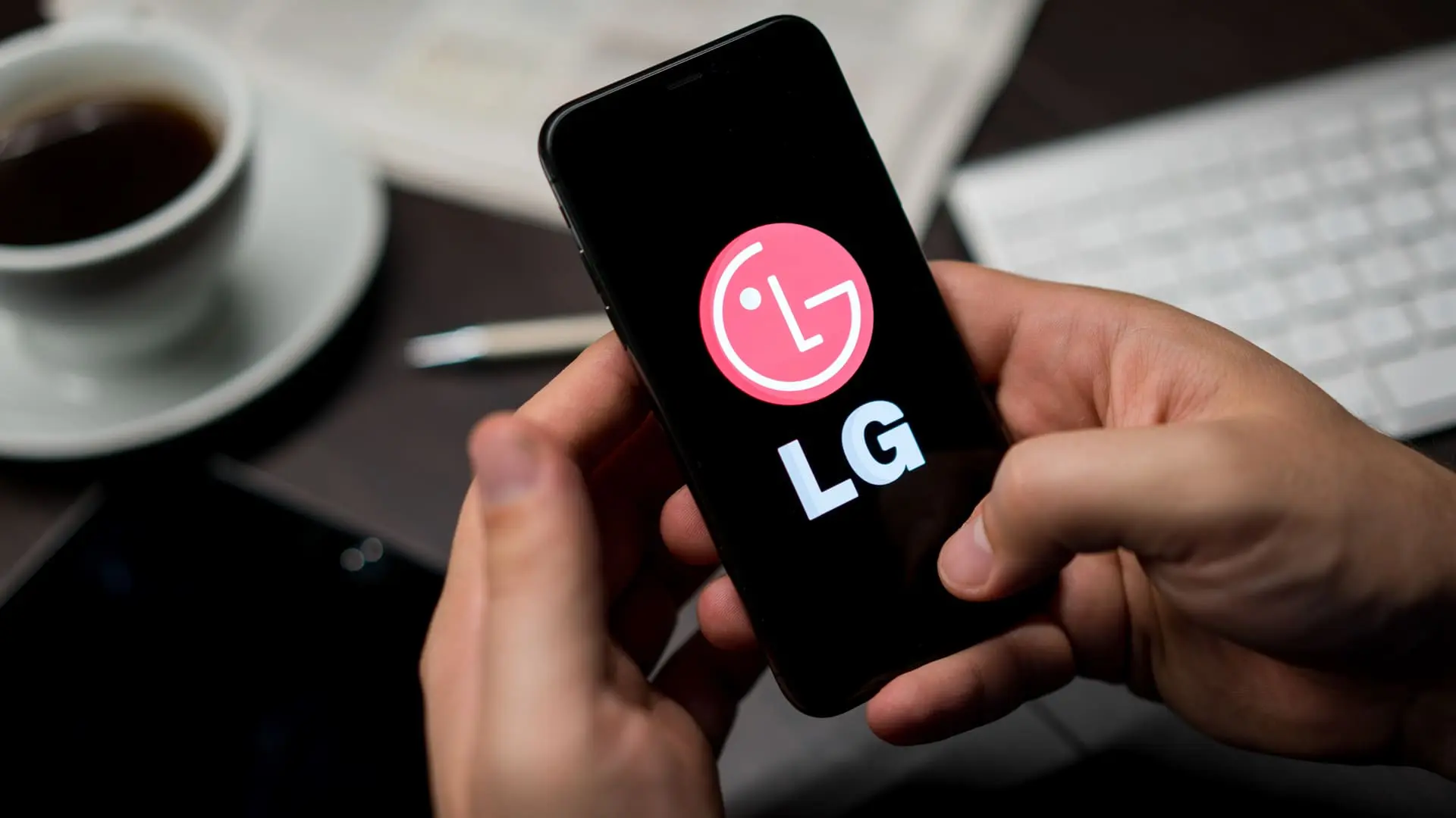 Mãos mexendo em um celular LG com a logo na tela