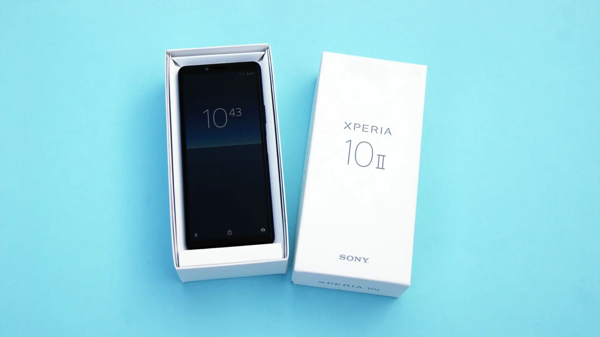 Celular da Sony dentro da sua caixa apoiado em uma superfície azul