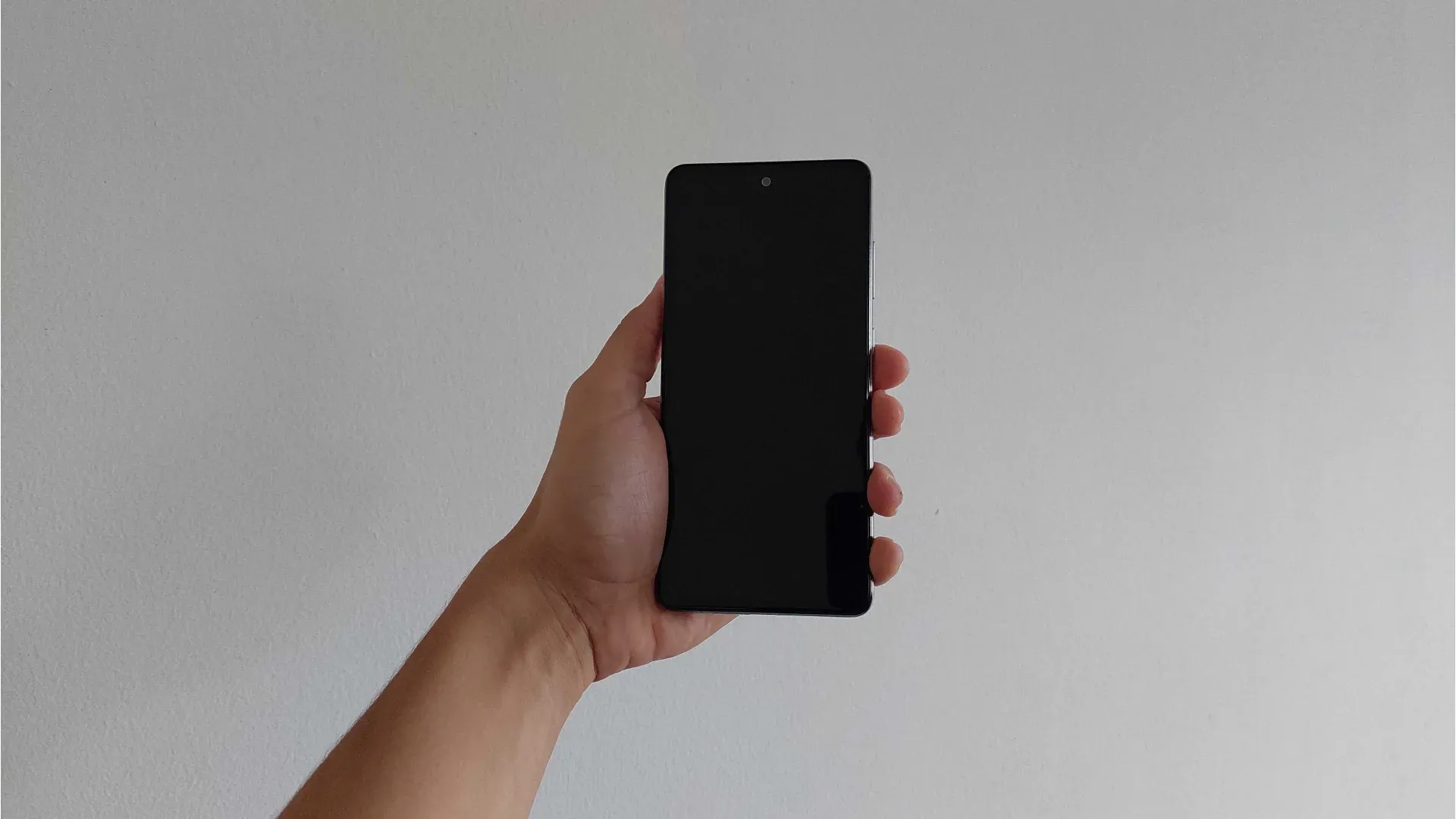 Foto de uma mão segurando o A52s 5G exibindo a parte frontal do aparelho