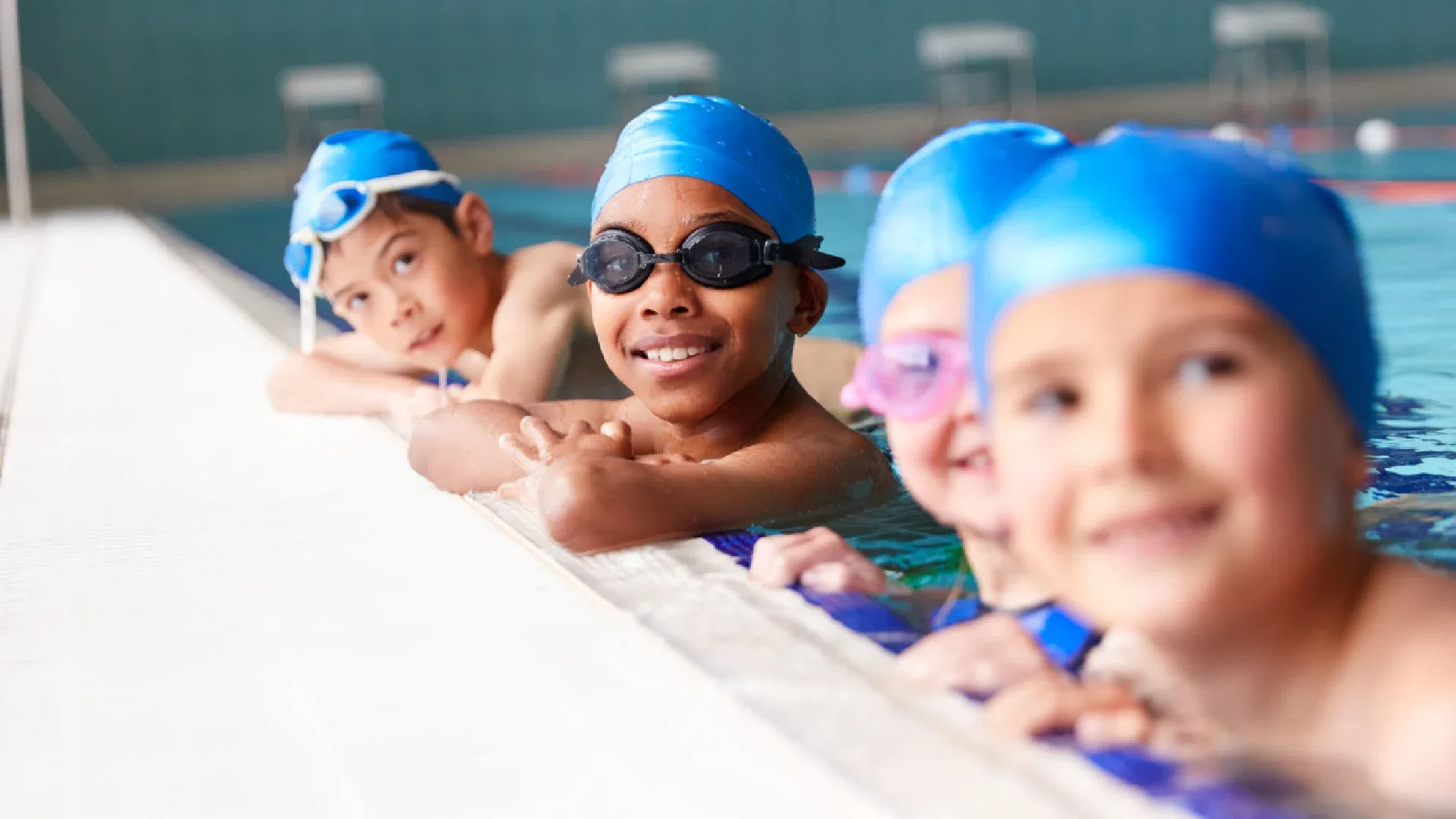 Crianças de touca de natação em piscina de natação