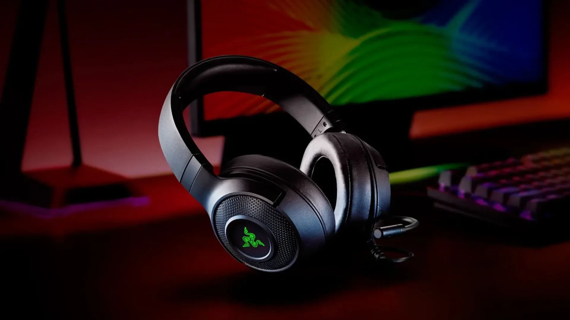 A imagem apresenta o headset Razer Kraken X USB em uma mesa com outros produtos da Razer.