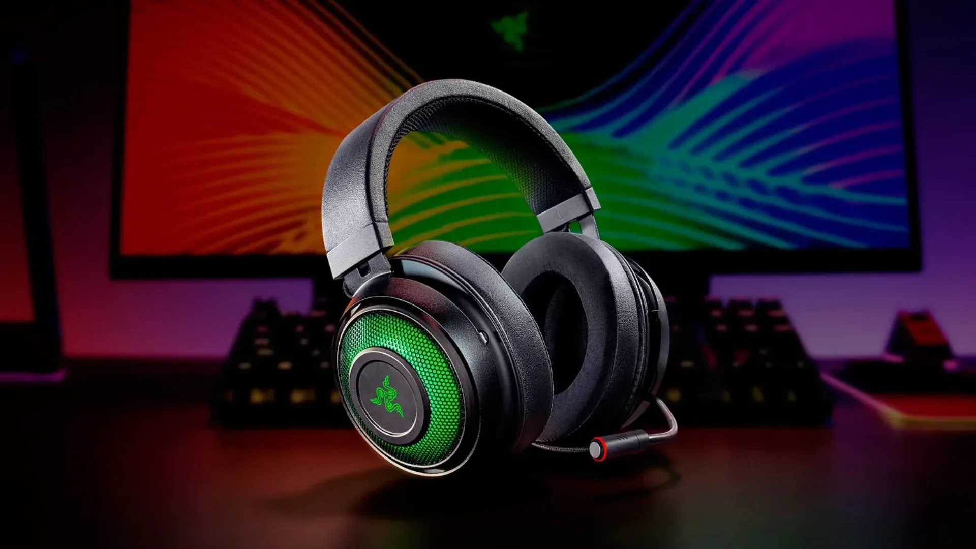 A imagem apresenta o headset Razer Kraken Ultimate com alguns outros produtos da Razer no fundo.