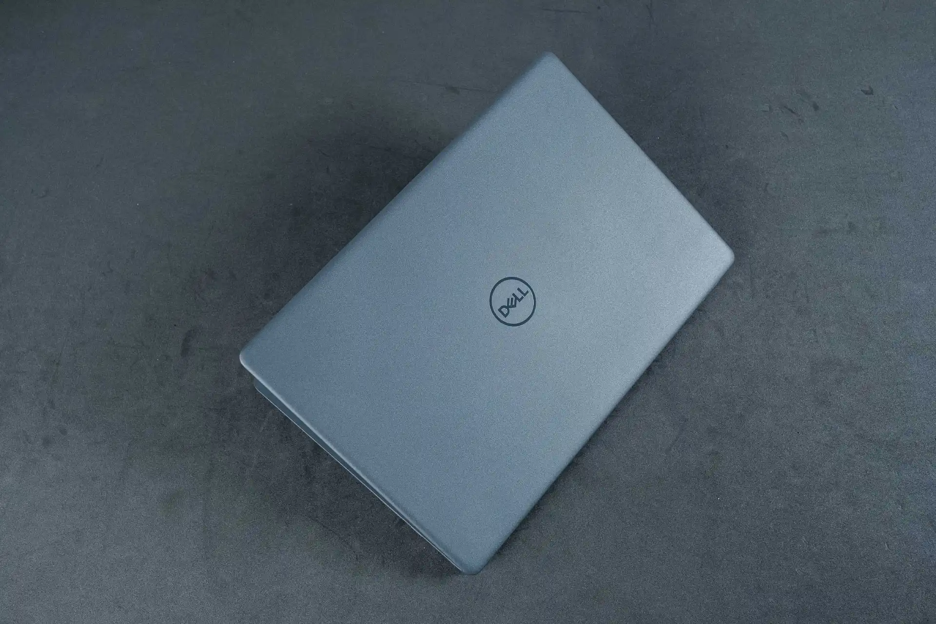 Foto de cima do Dell Inspiron 3000 semiaberto, com logo da Dell no centro