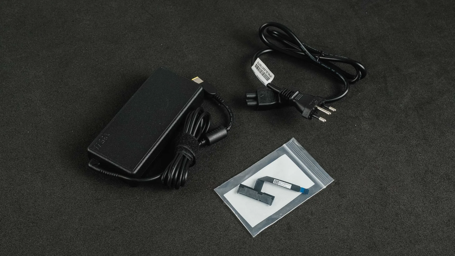 Cabo de energia de kit de atualização do Lenovo IdeaPad Gaming 3i em cima de uma superfície cinza