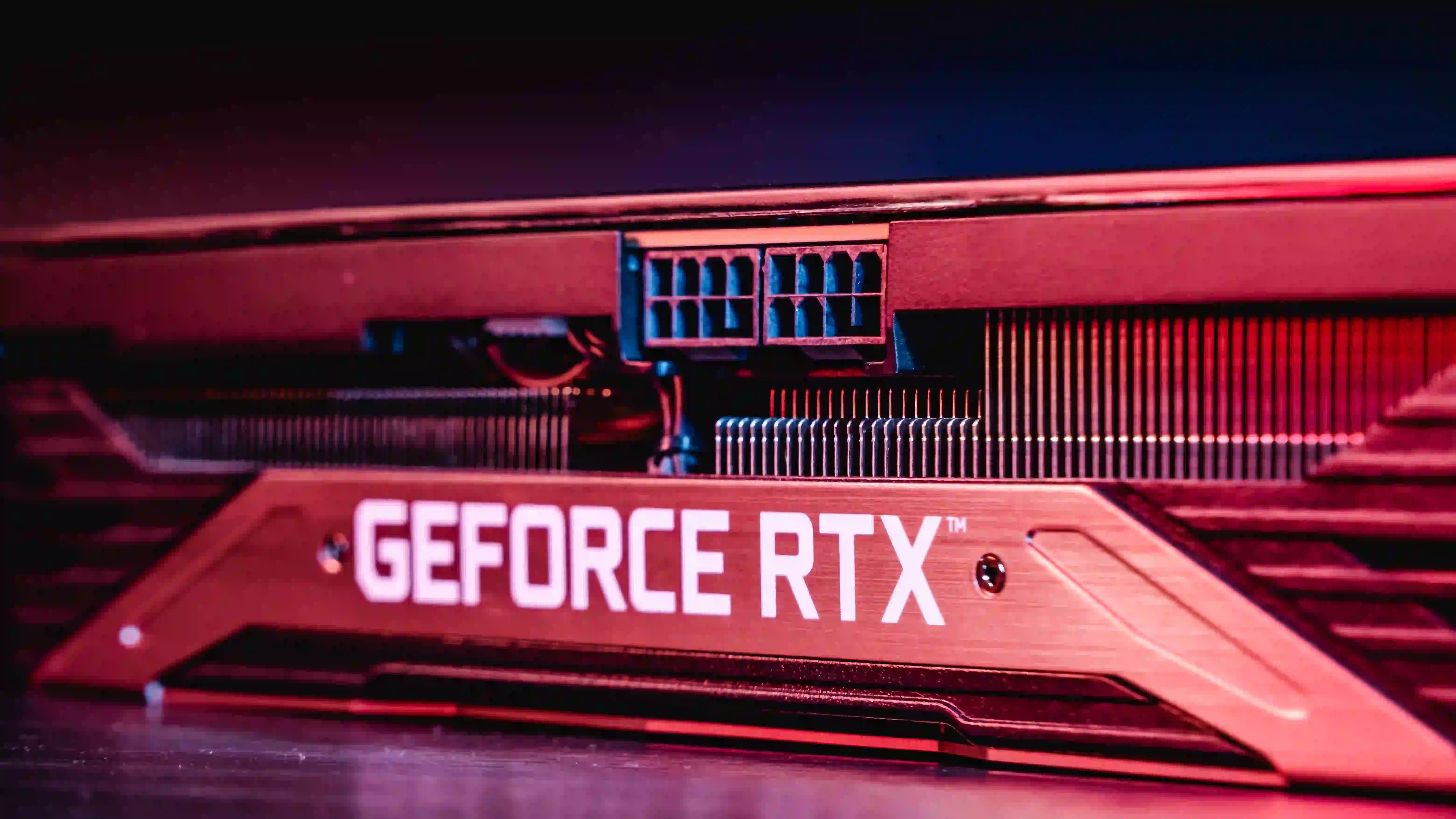 A imagem exibe uma RTX 3060 12GB vista de perto, com uma luz avermelhada a iluminando.