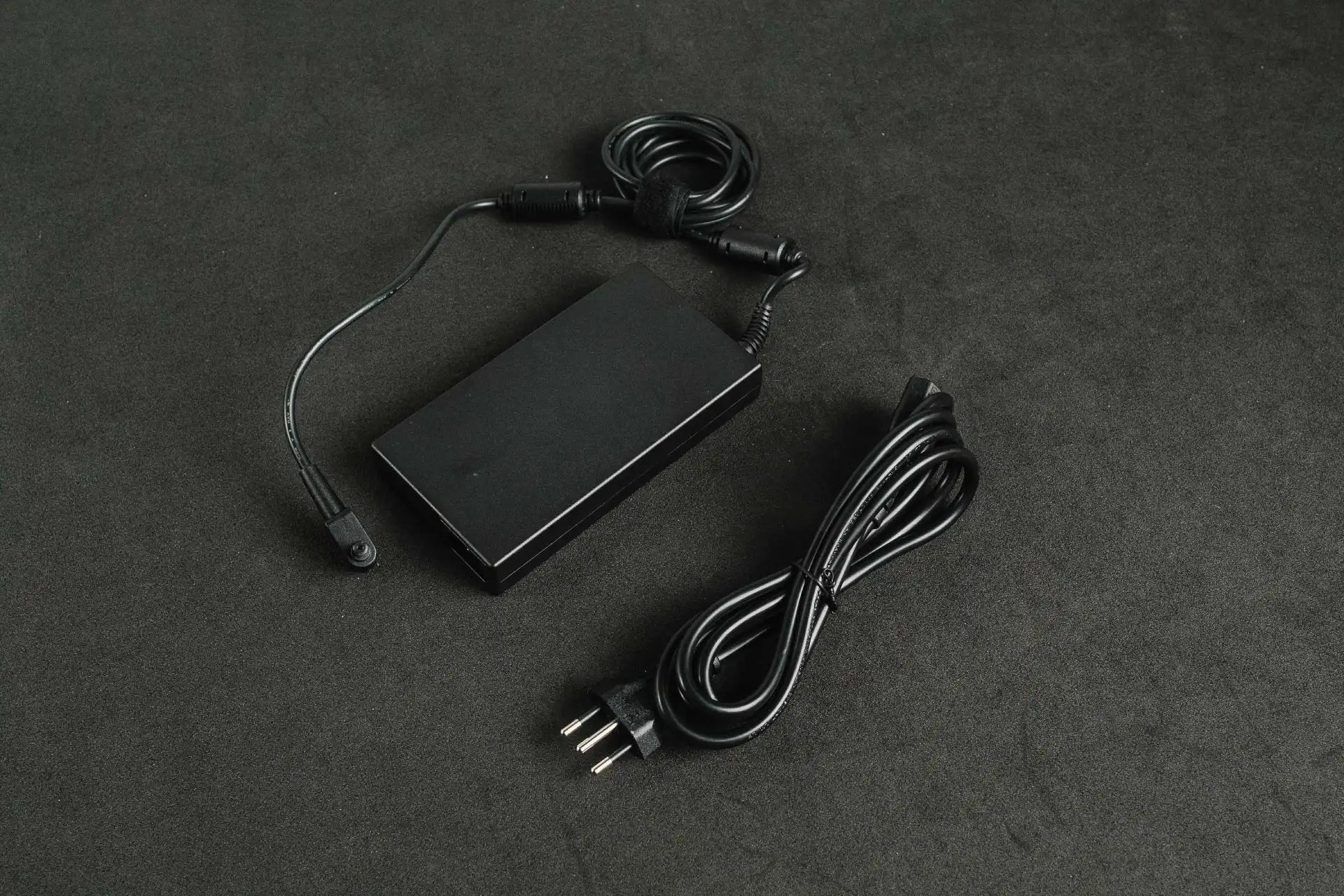 Carregador preto do Acer Predator Helios 300 sobre mesa também preta