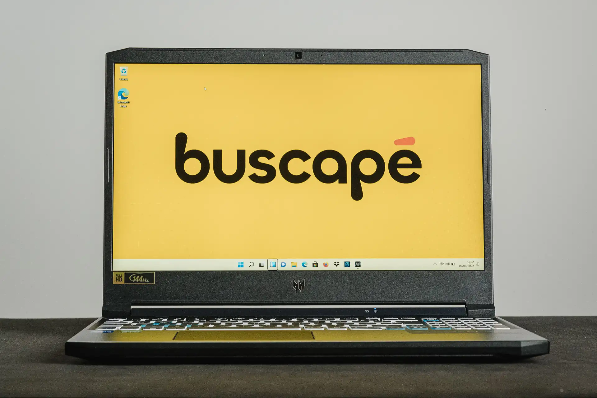 Notebook Acer Predator Helios 300 aberto sobre mesa preta e com papel de parede do Buscapé