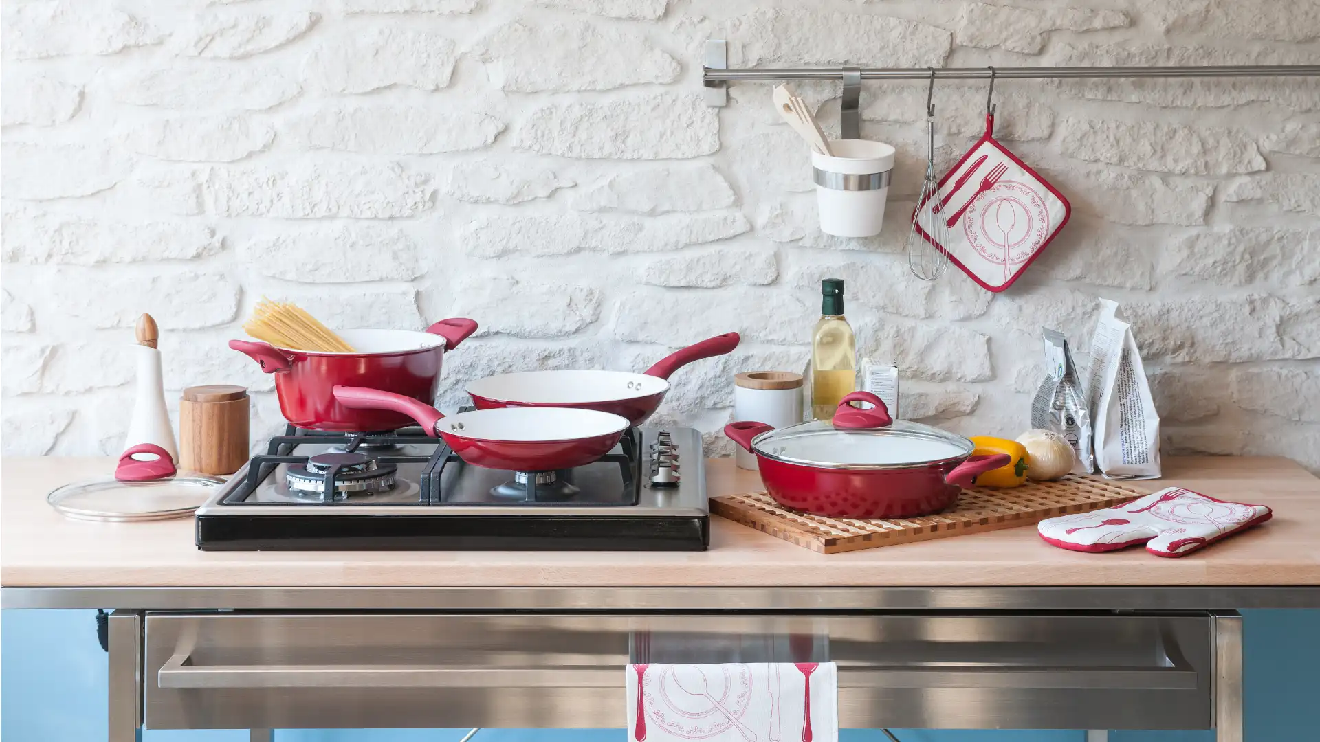 Balcão de cozinha com cooktop e panelas coloridas