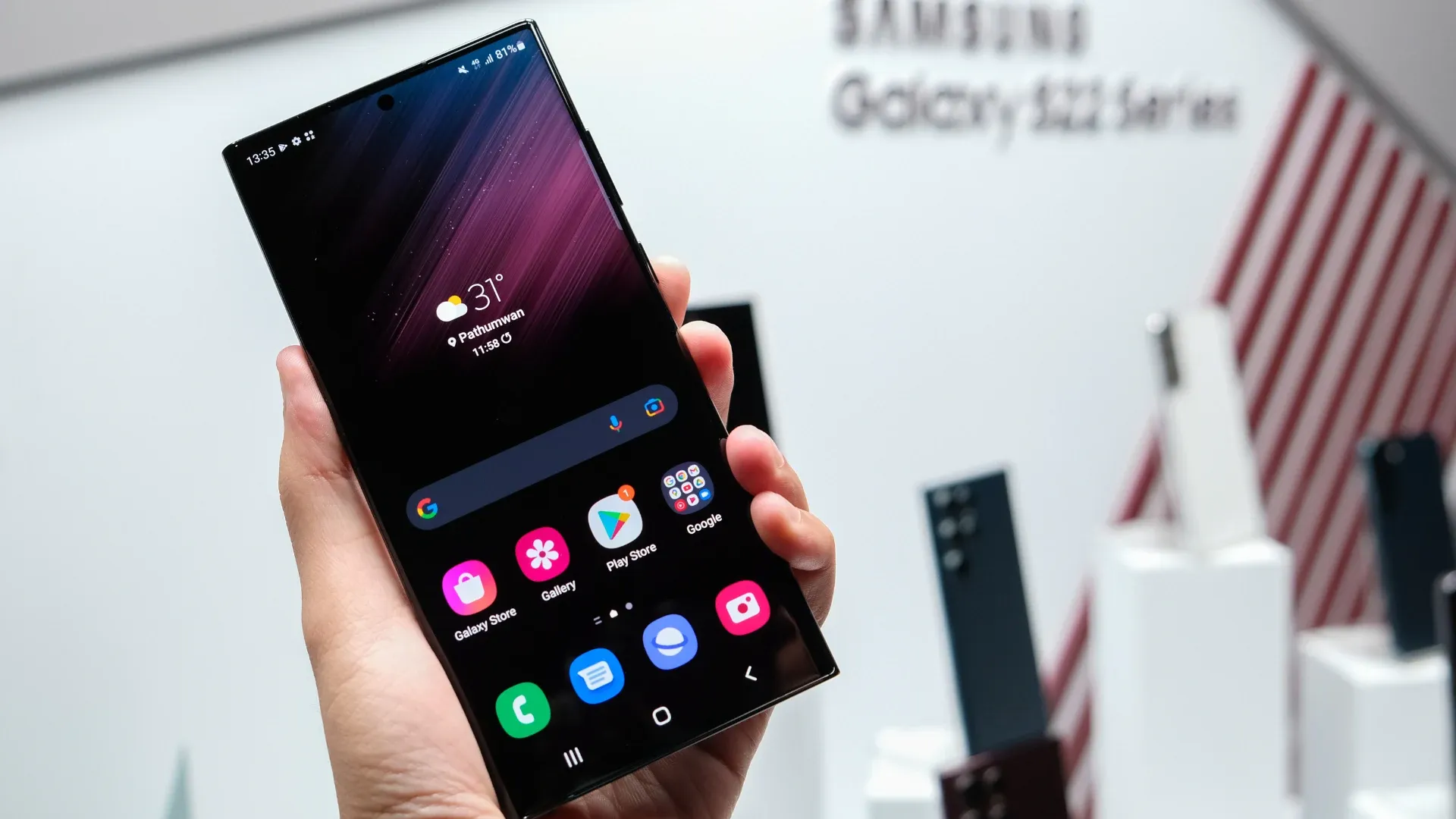 Imagem de uma pessoa segurando o Galaxy S22 Ultra com a tela ligada