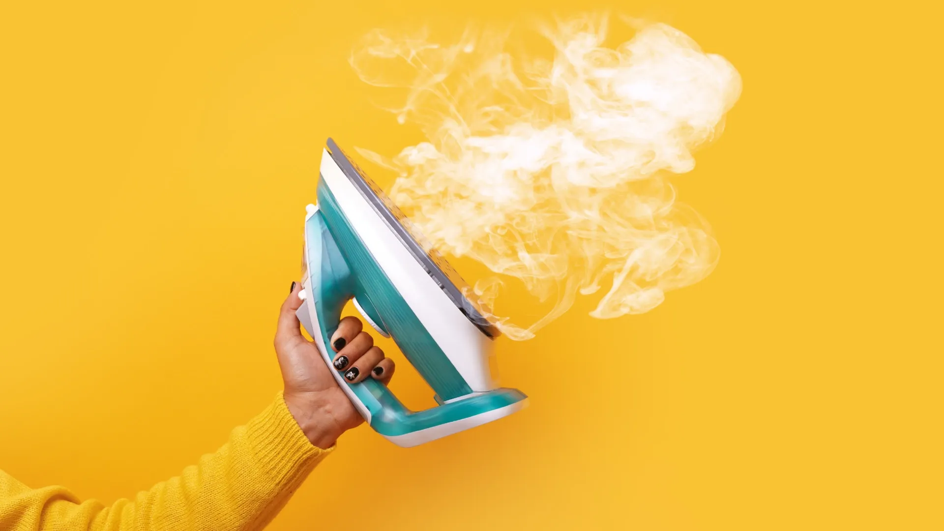 Ferro a vapor soltando verde e branco vapor com parede amarela atrás