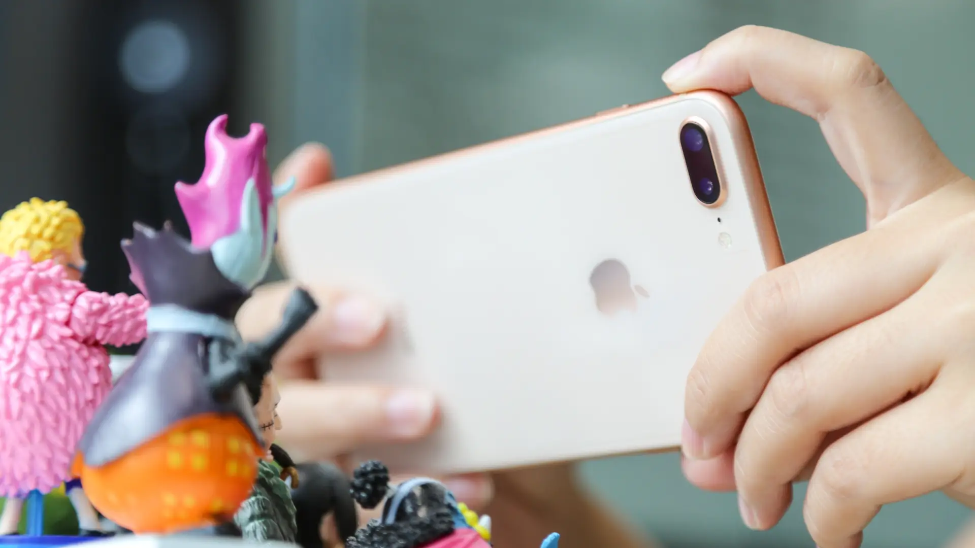 Mão de usuário tirando foto de brinquedos com seu iPhone 8 Plus usado
