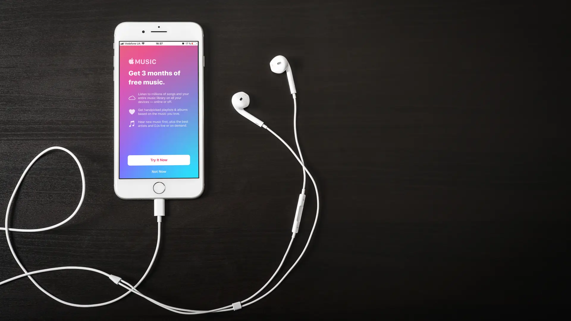 iPhone 8 usado com seu fone de ouvido sobre mesa de madeira