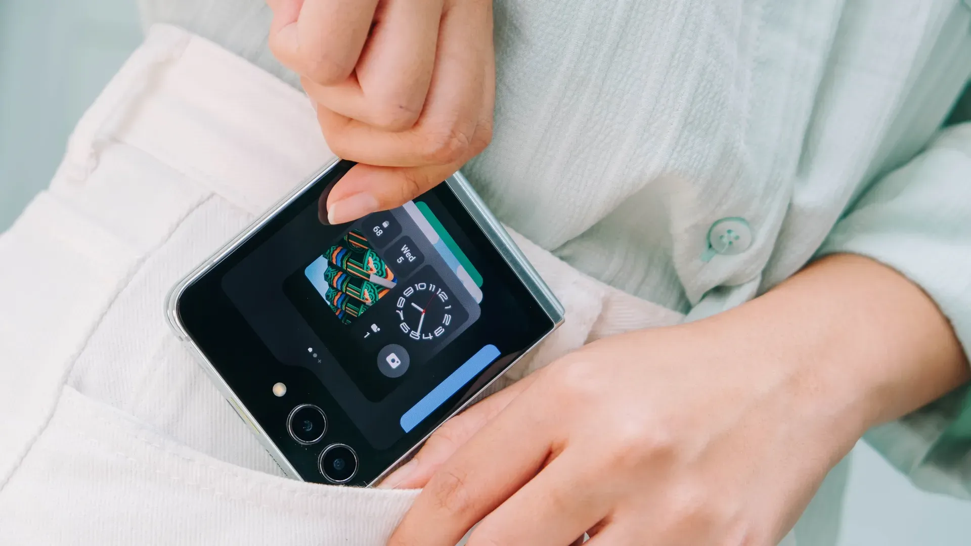 Uma pessoa está com um celular dobrável próximo ao bolso