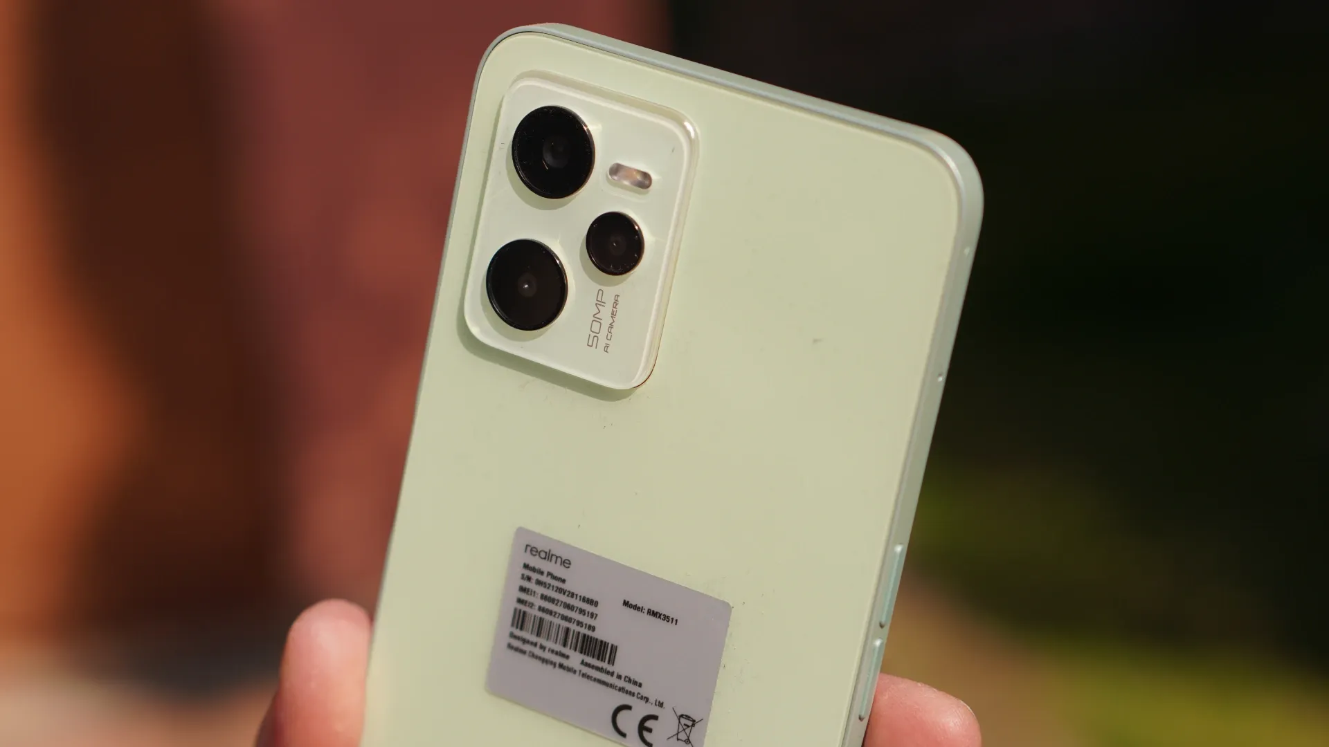 Um celular branco está sendo mostrado pela parte traseira