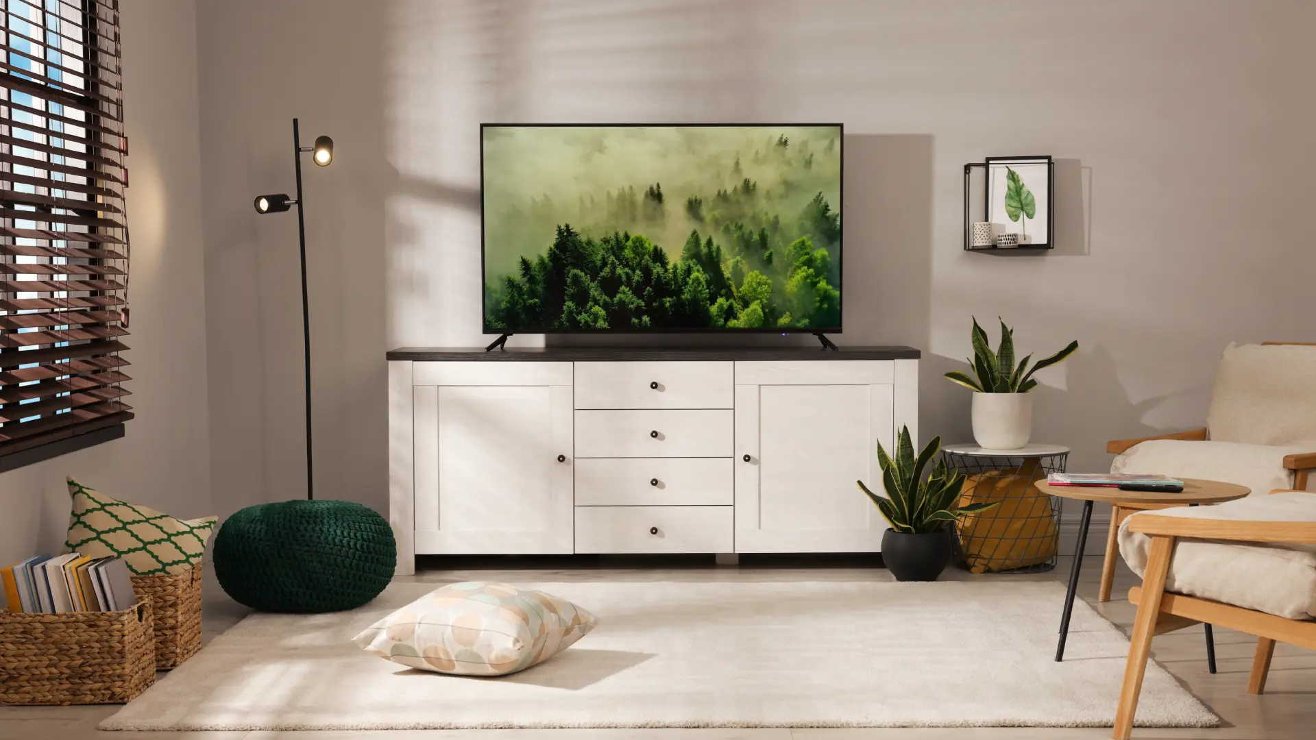 TV em cima de um hack branco em uma sala com tons claros e plantas